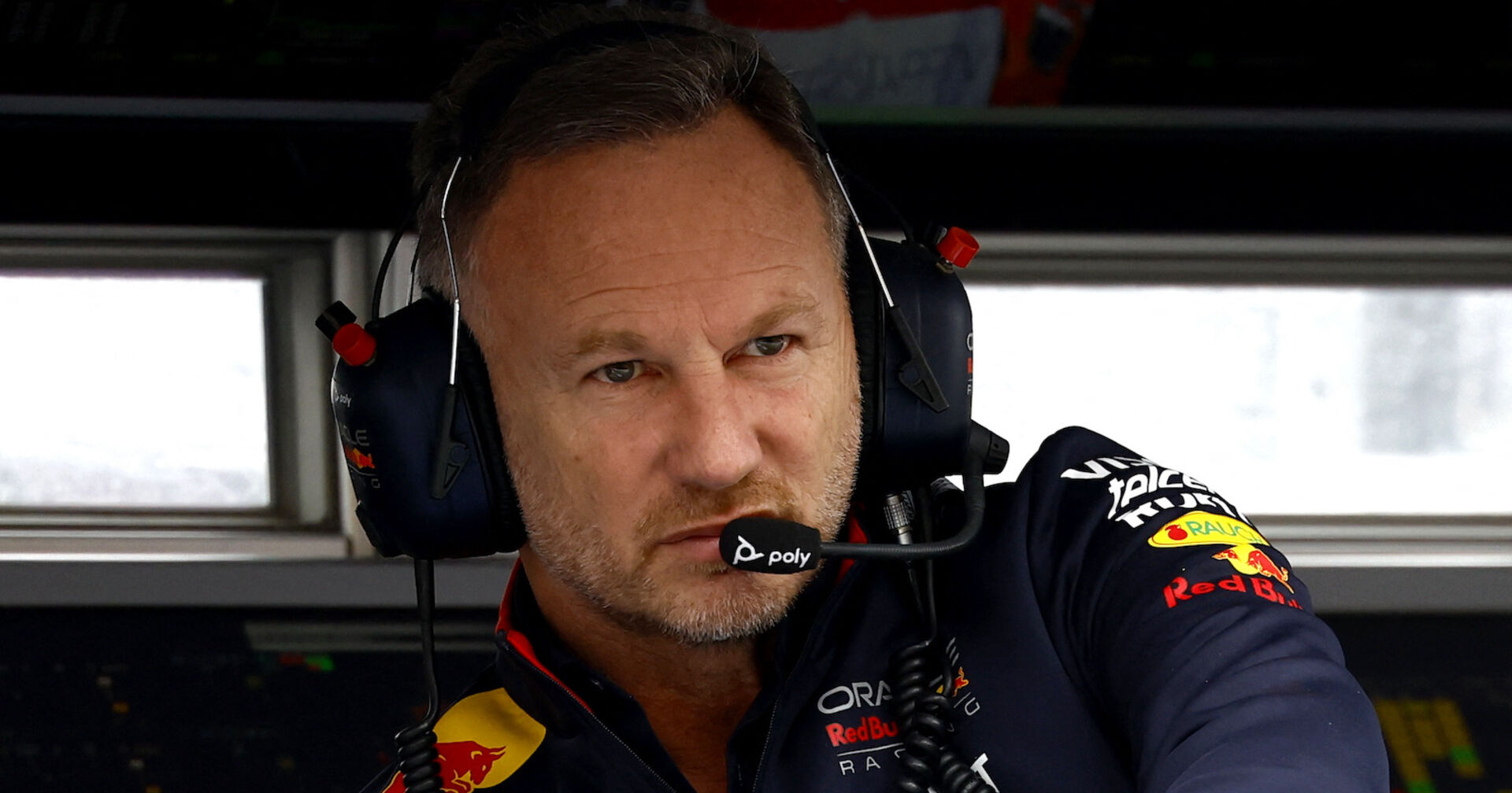 Christian Horner auf der Rennstrecke, er schaut sehr ernst und konzentriert. Er trägt ein Funkset