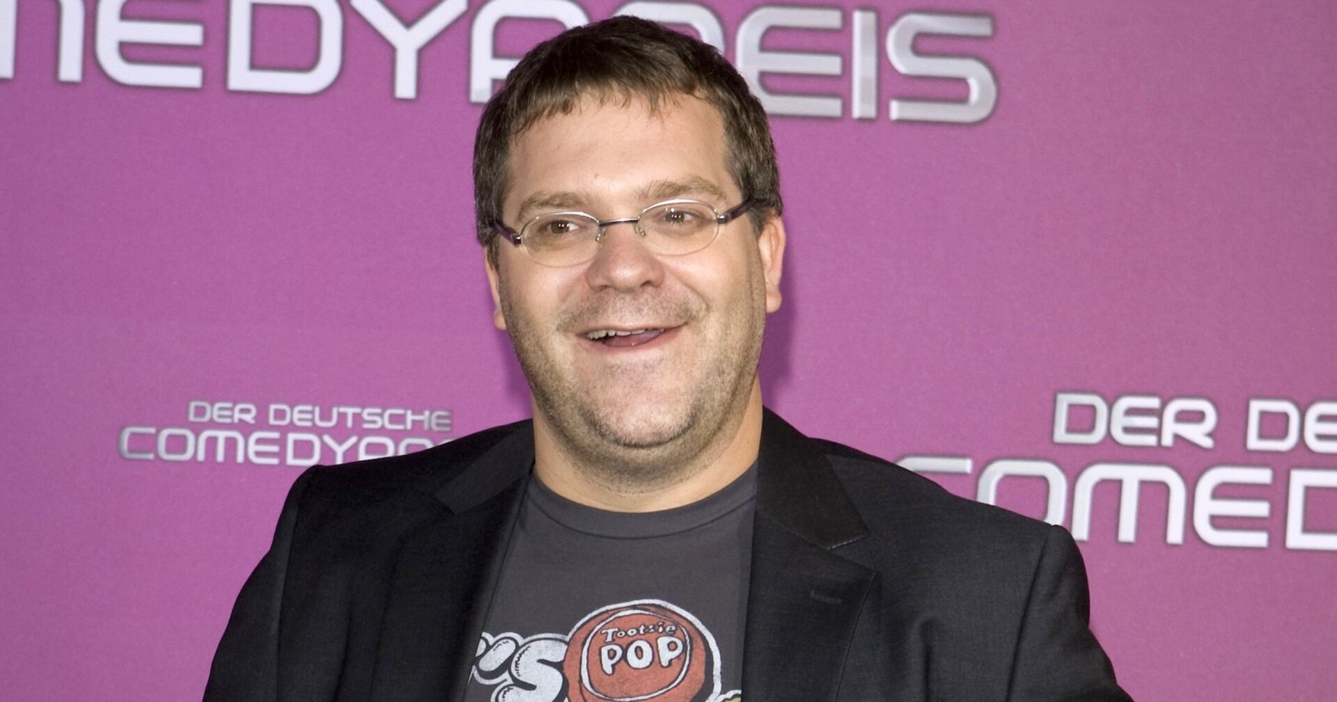 Elton vor einer pinken Wand.