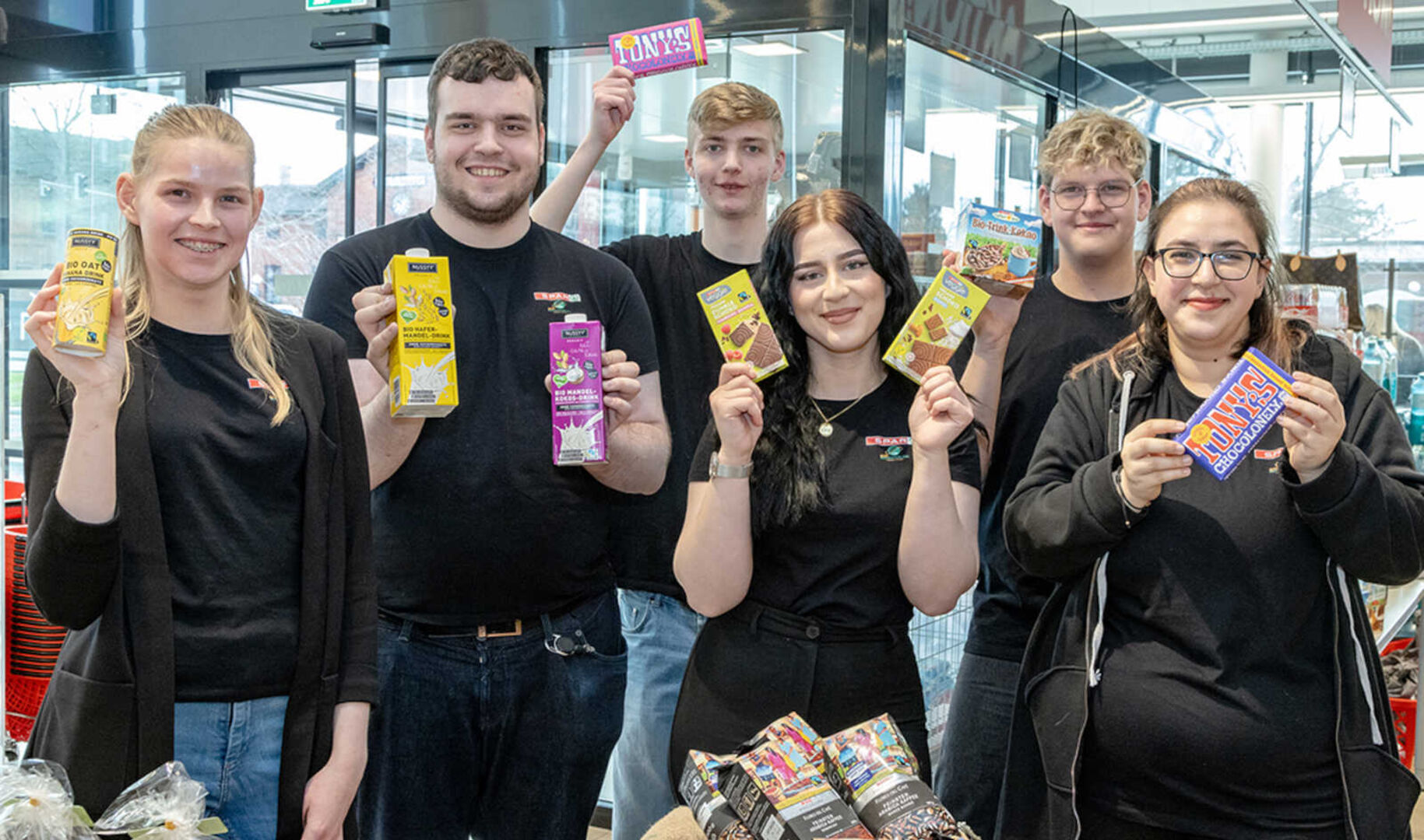 Mehrere Jugendliche halten verschiedene Lebensmittel-Produkte in die Kamera