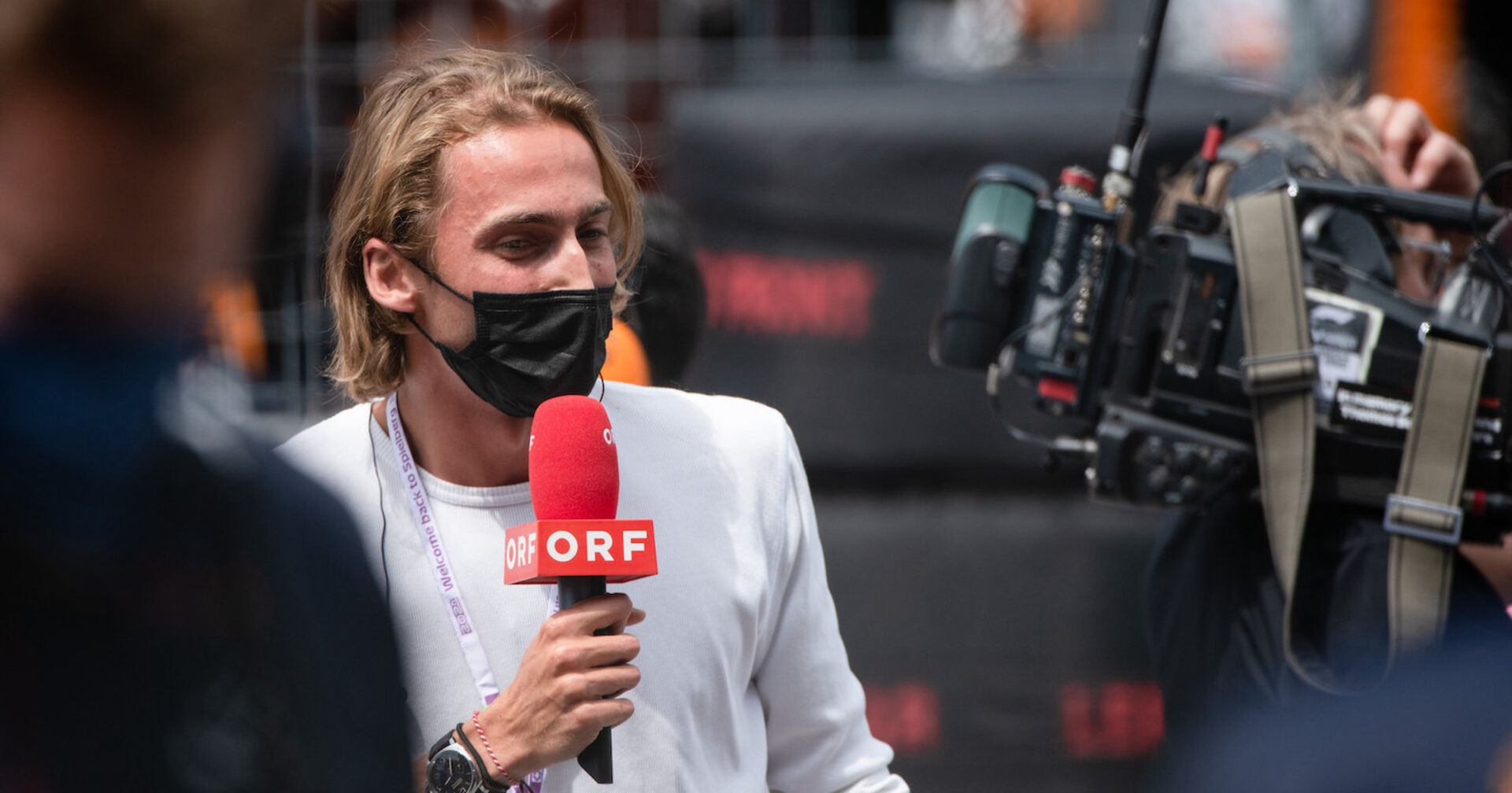 Ferdinand Habsburg mit einer FFP2-Maske und ORF-Mikrofon vor einer Kamera