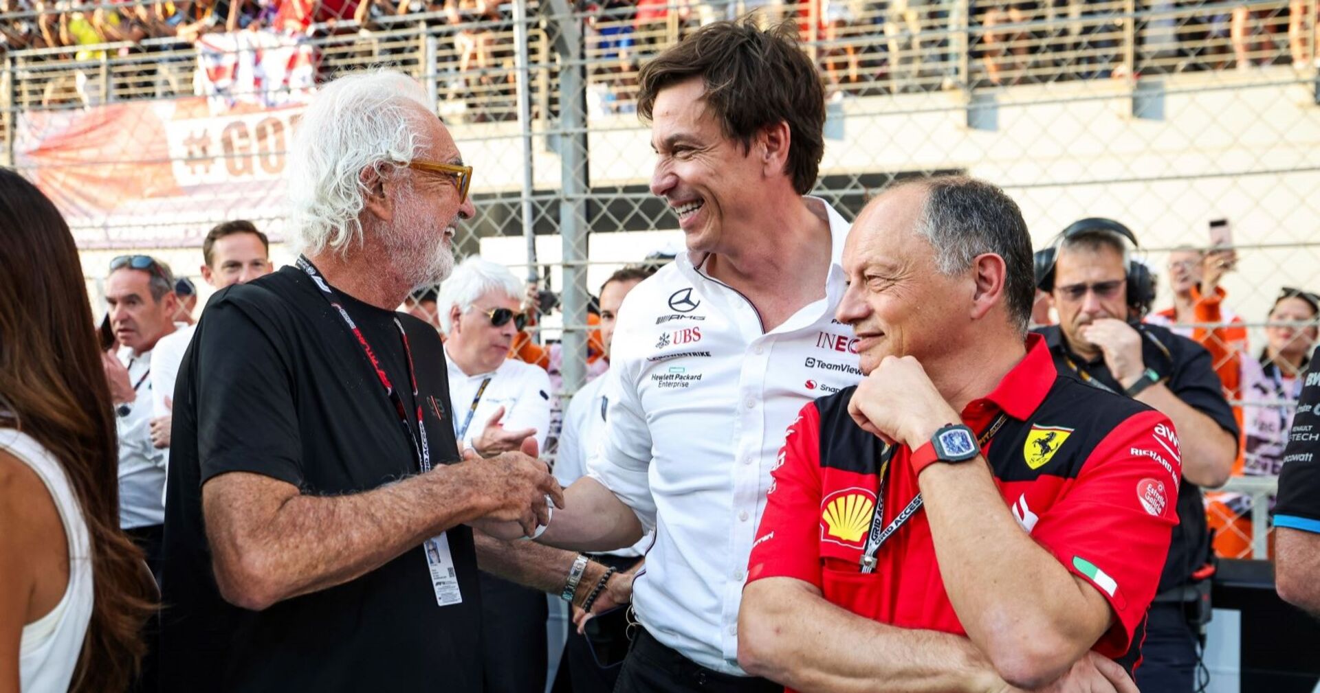 Flavio Briatore, Toto Wolff und Frédéric Vasseur stehen lachend zusammen.