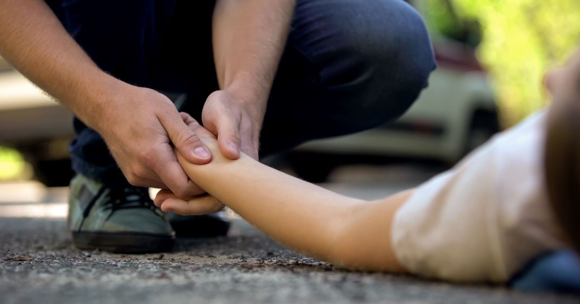 Jemand kontrolliert den Puls einer bewusstlosen Frau.