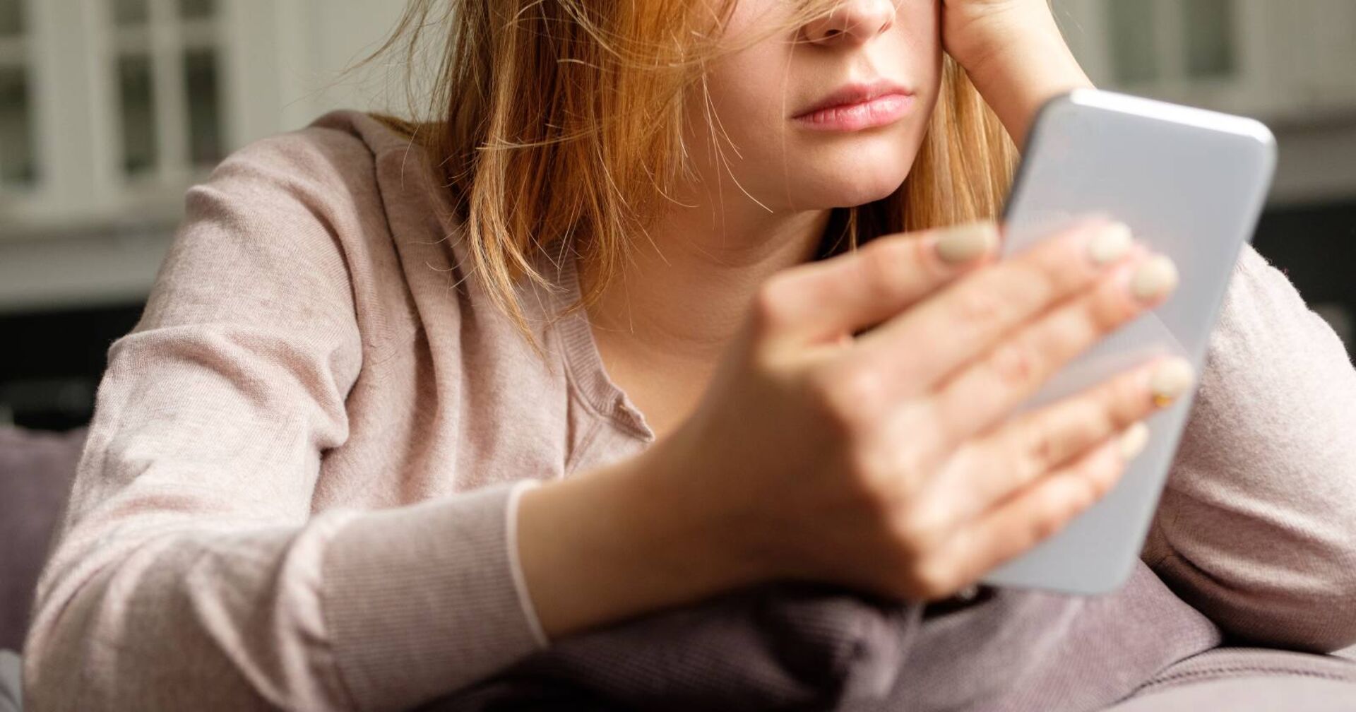Frustrierte junge Frau mit einem Smartphone in der Hand