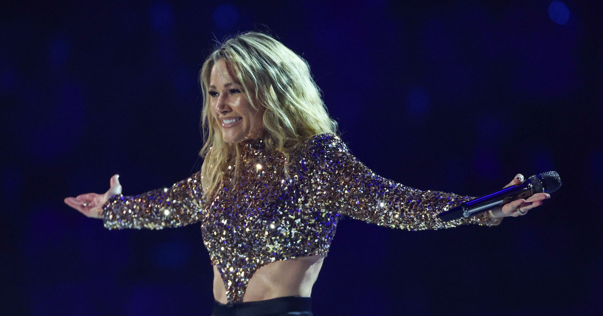 Helene Fischer mit einem Glitzertop auf der Bühne. Sie trägt offene blonde Haare.