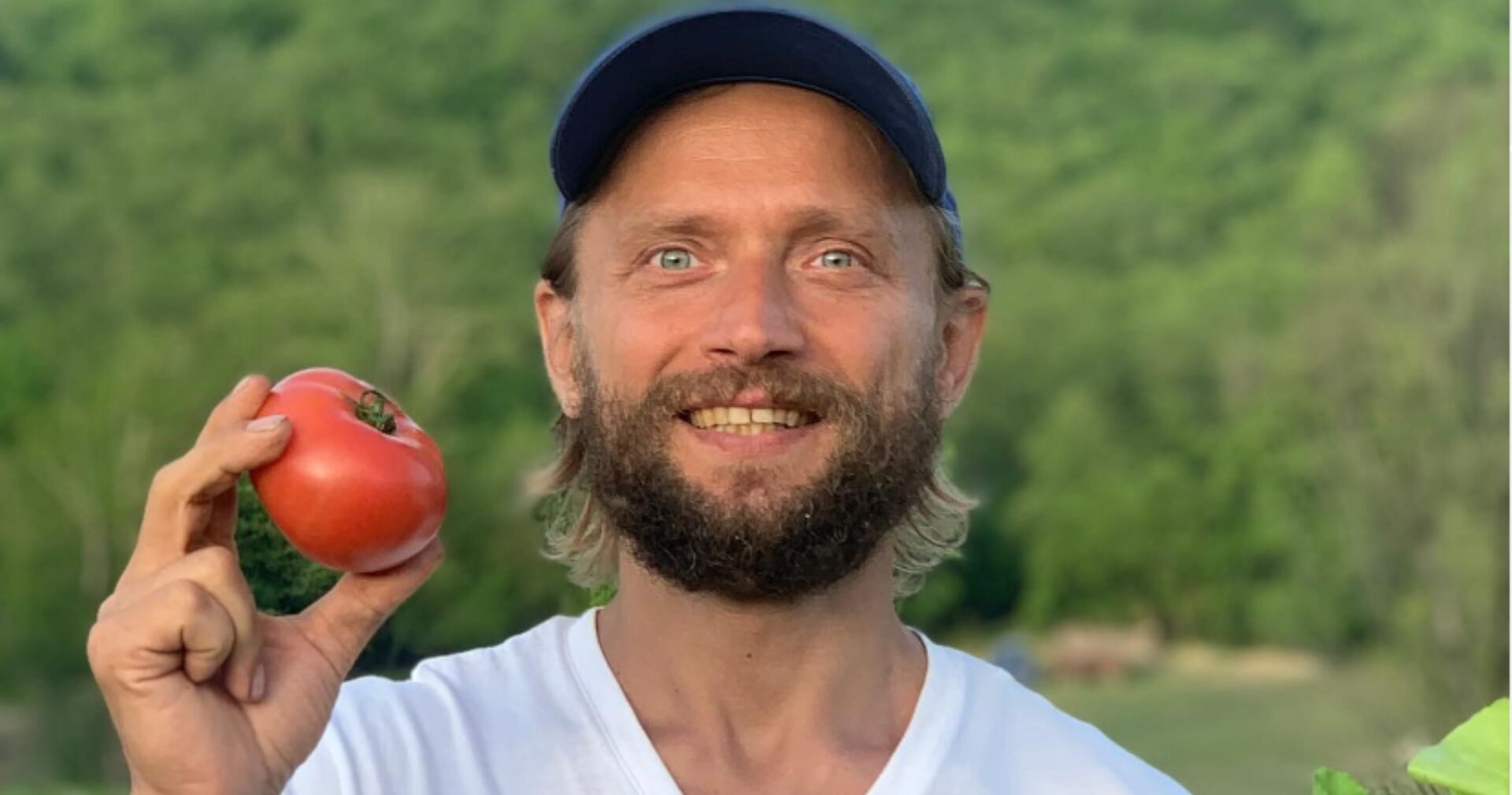 &quot;Influencer&quot; Maxim Lyutyi lächelnd und mit einer Tomate in der Hand.