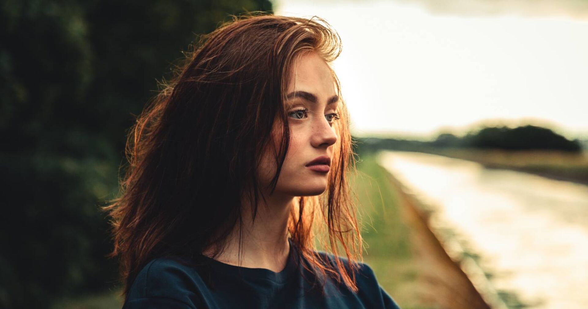 Nahaufnahme des Gesichts einer jungen Frau mit in die Ferne gerichtetem Blick