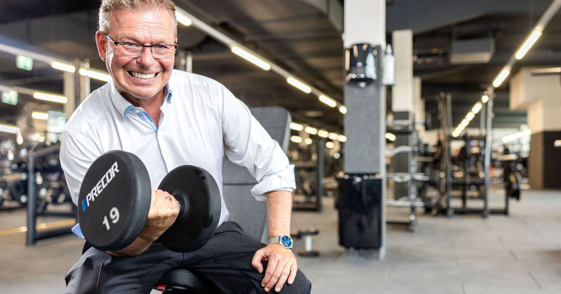 Gernot Jung stemmt im Hemd eine Hantel