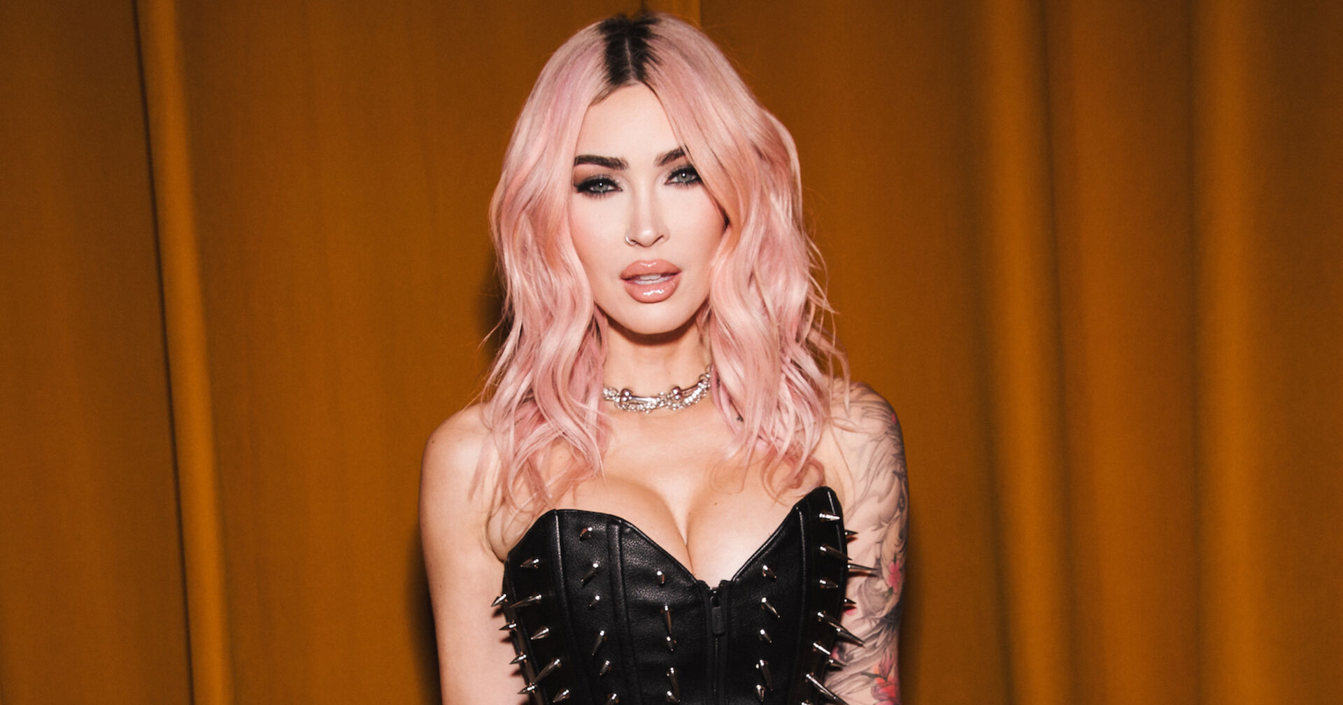 Megan Fox mit rosa Haaren und einer Coursage mit Nieten.