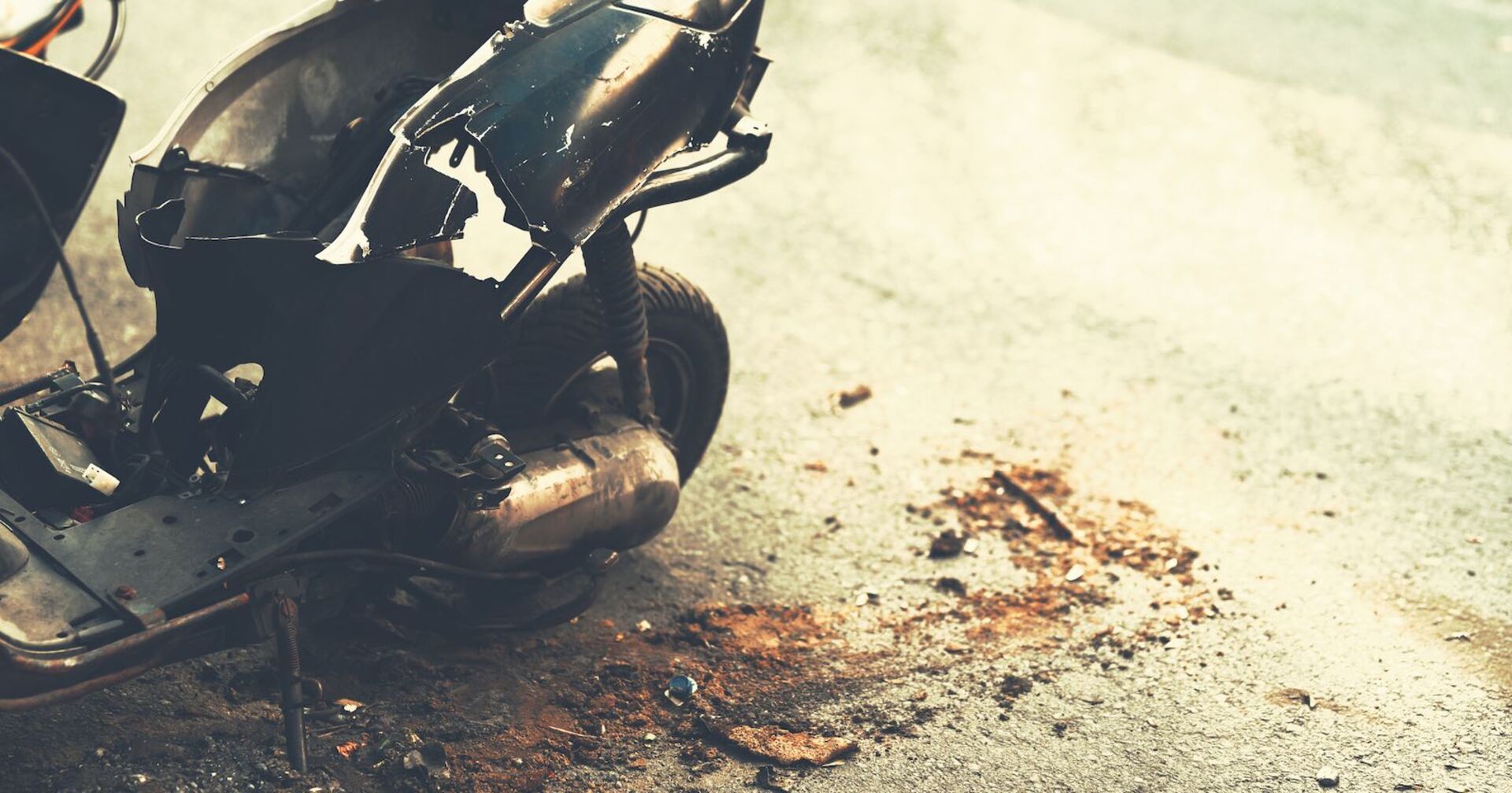 Ein verunfalltes Mofa auf einer Straße.