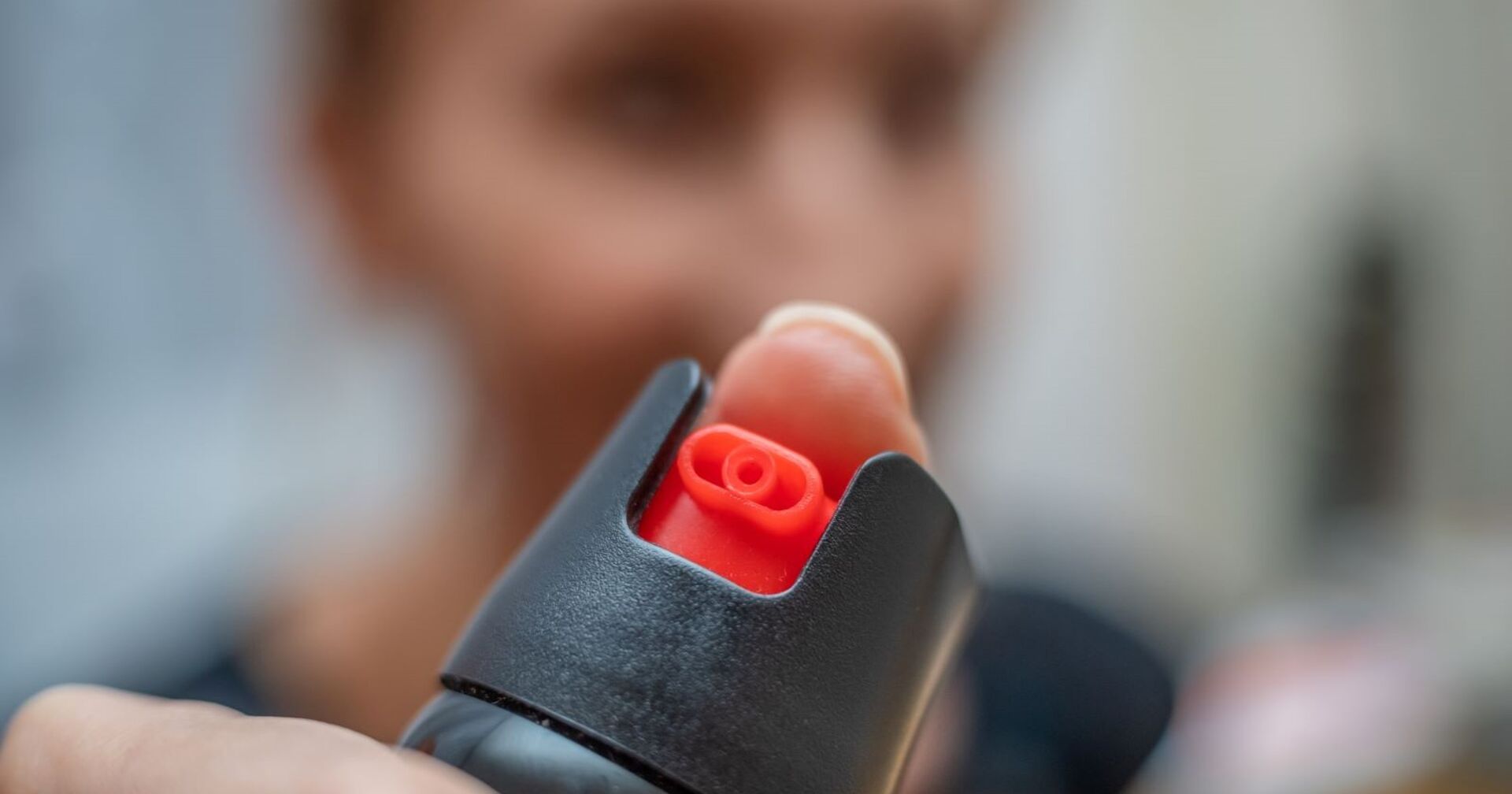 Ein Bub hält einen Pfefferspray in der Hand.