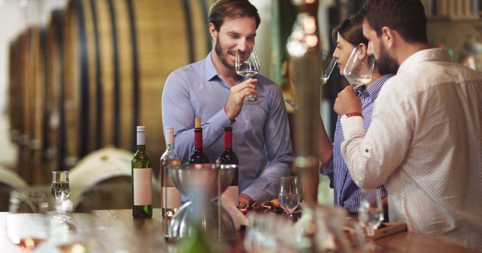 Drei Menschen bei einer Weinverkostung