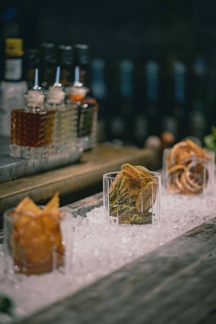 Gefüllte Gläser mit gefriergetrockneten Orangenscheiben in einer Eiswanne