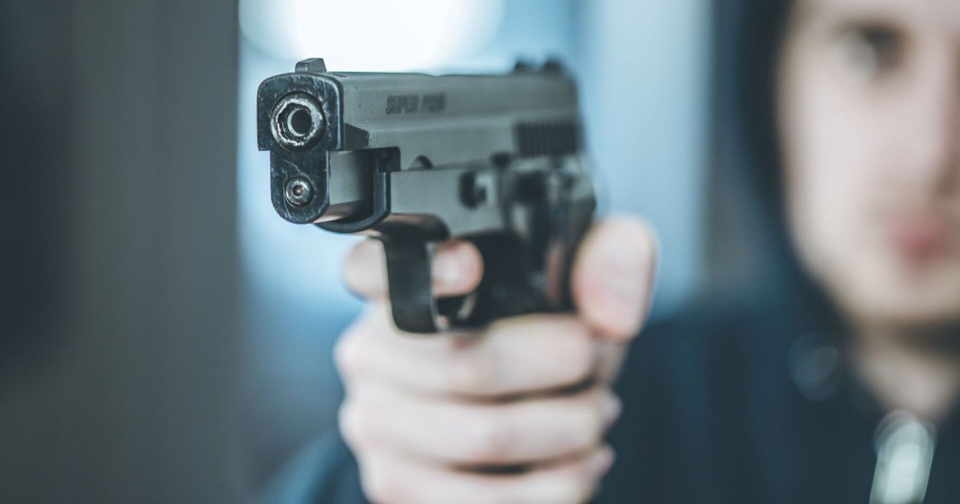 Ein junger Mann hält eine Schreckschusswaffe in der Hand.