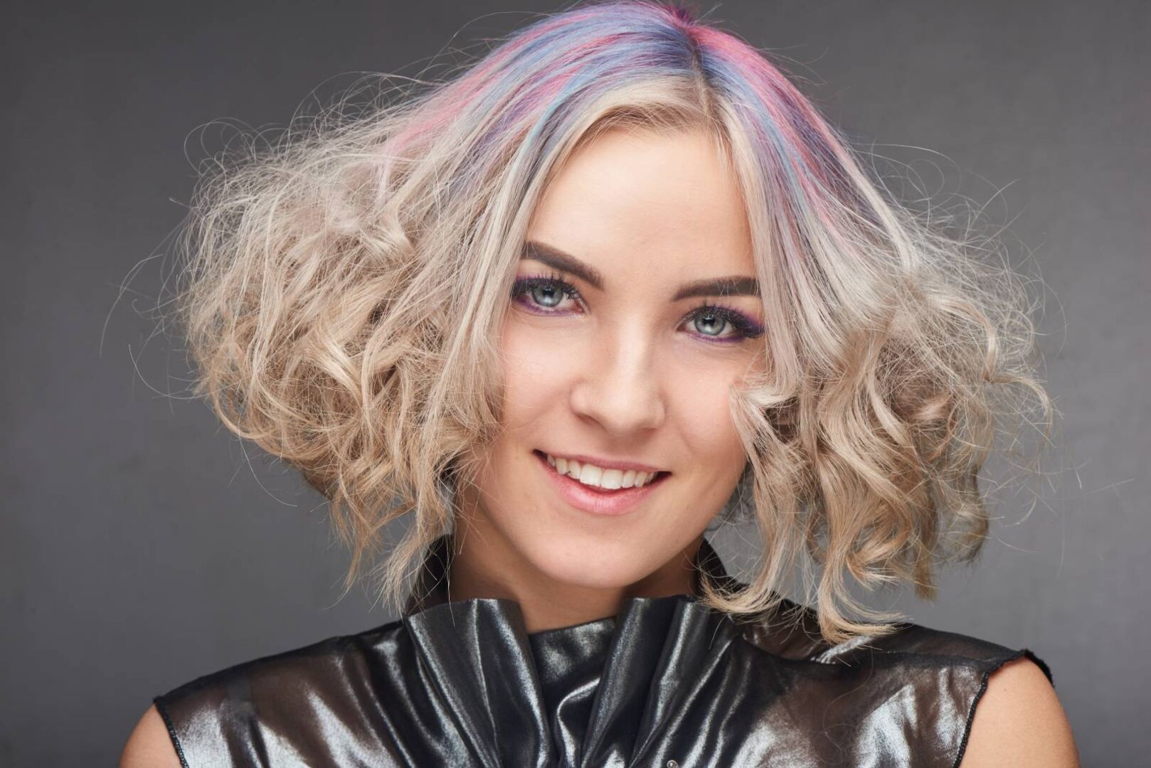 Attraktive Frau mit blonden Haaren mit bunten Strähnchen und hellen Augen