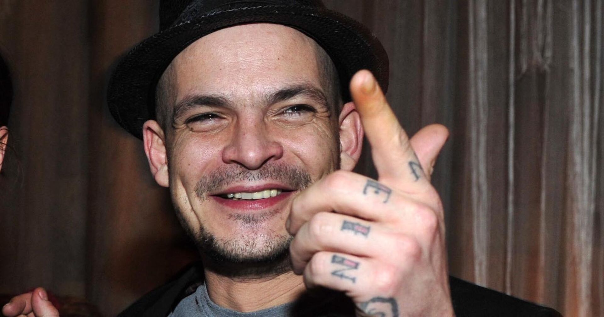 Ben Tewaag mit Tattoos auf den Händen und einem Hut.