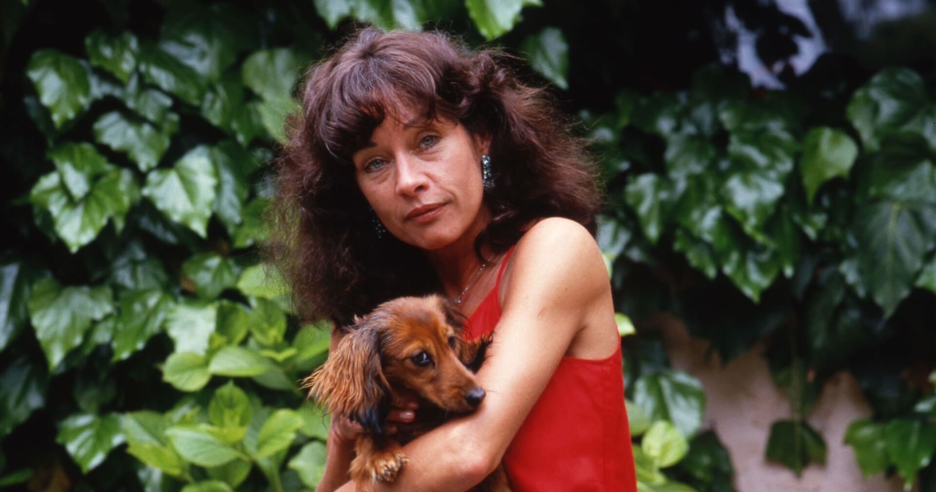 Vera Tschechowa 1987 mit einen Dackel auf dem Arm.