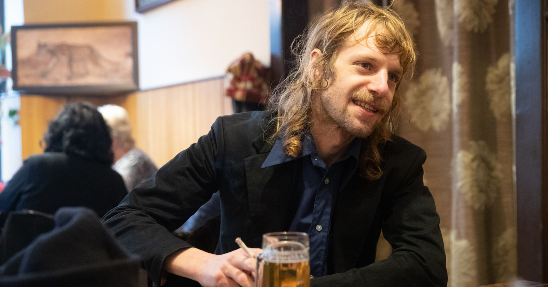 Vodoo Jürgens in einem schwarzen Sakko und einem Vokuhila.