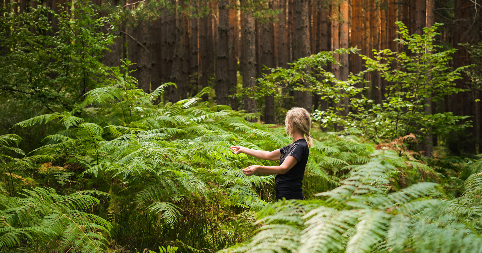 Frau steht mitten im Wald | Credit: iStock.com/ed chechine