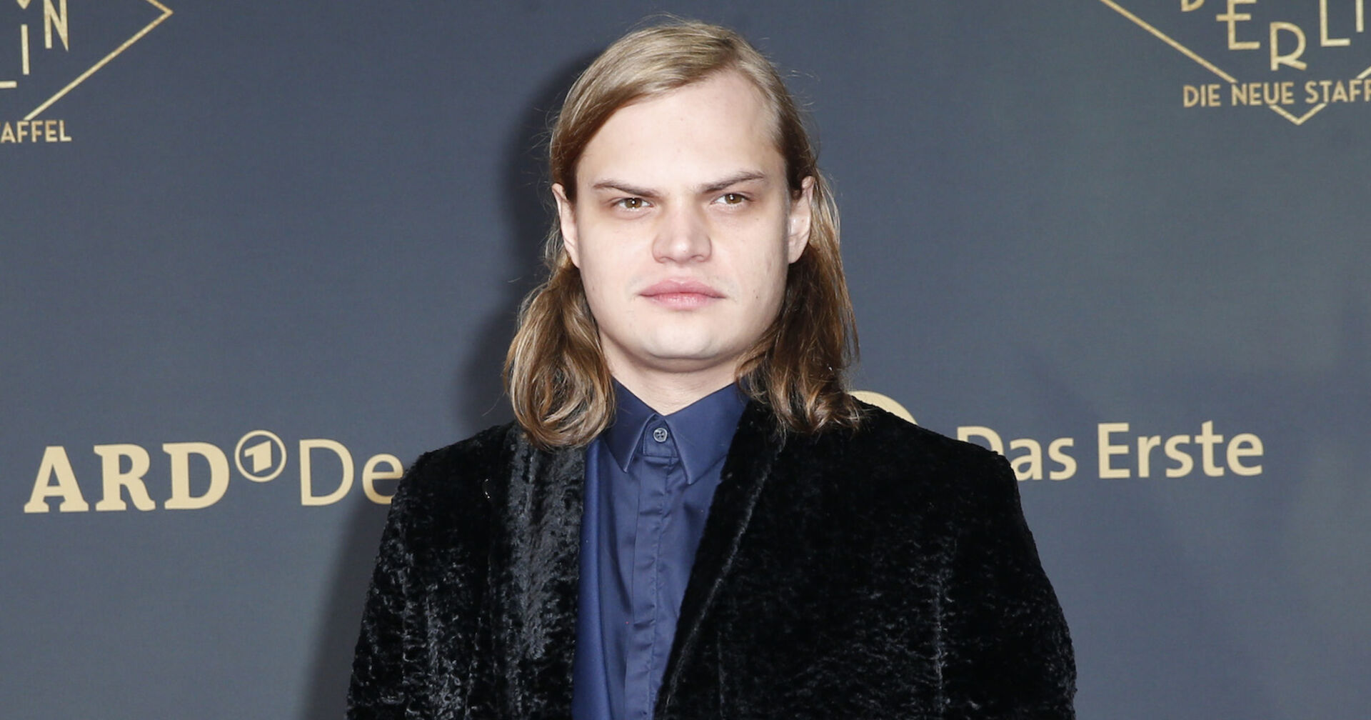 Wilson Gonzales Ochsenknecht mit einem blauen Hemd und einem schwarzen Mantel