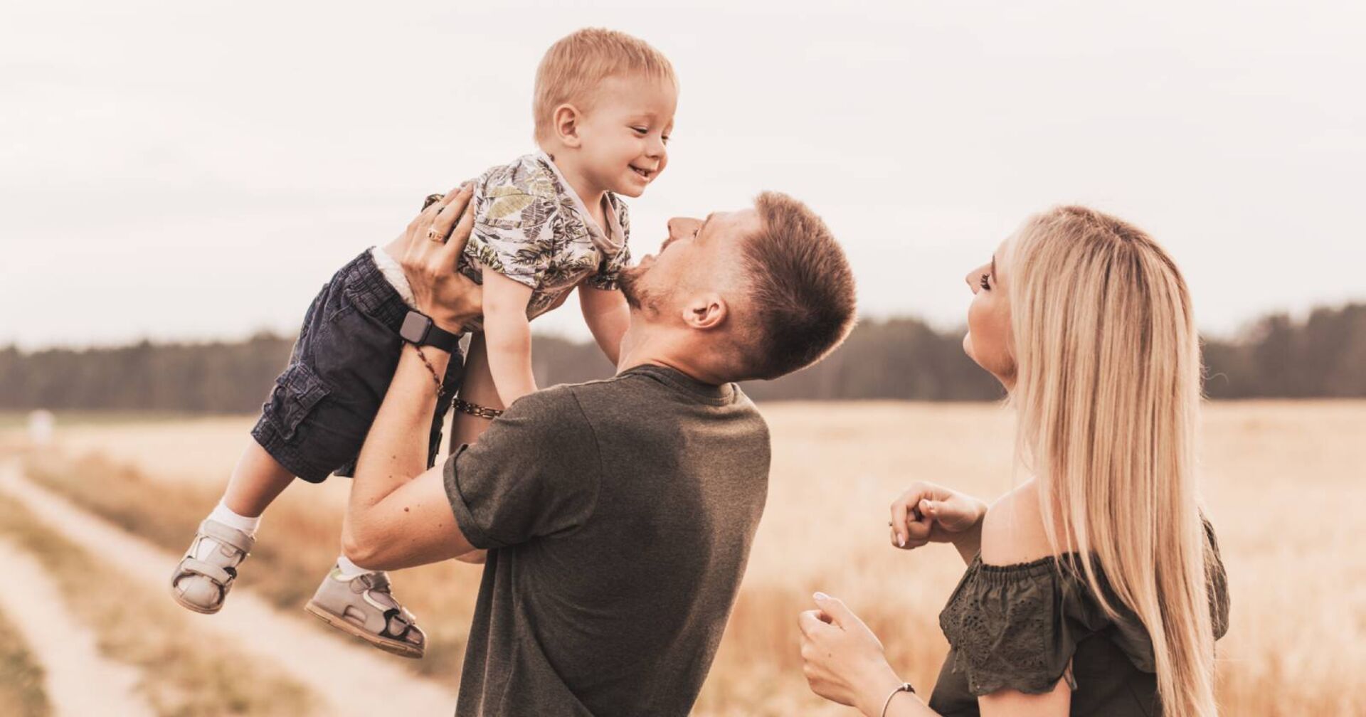 Junges Paar, das zusammen mit ihrem Baby bei einem Wochenendausflug spielt.