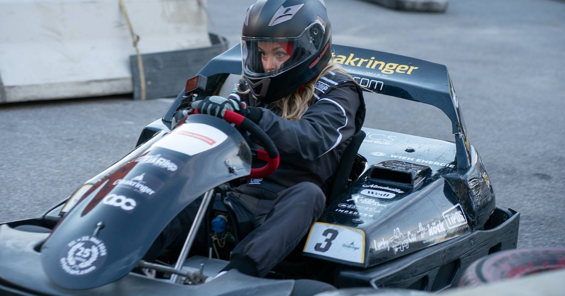 Marina Hörmanseder im Rennauto und mit Helm