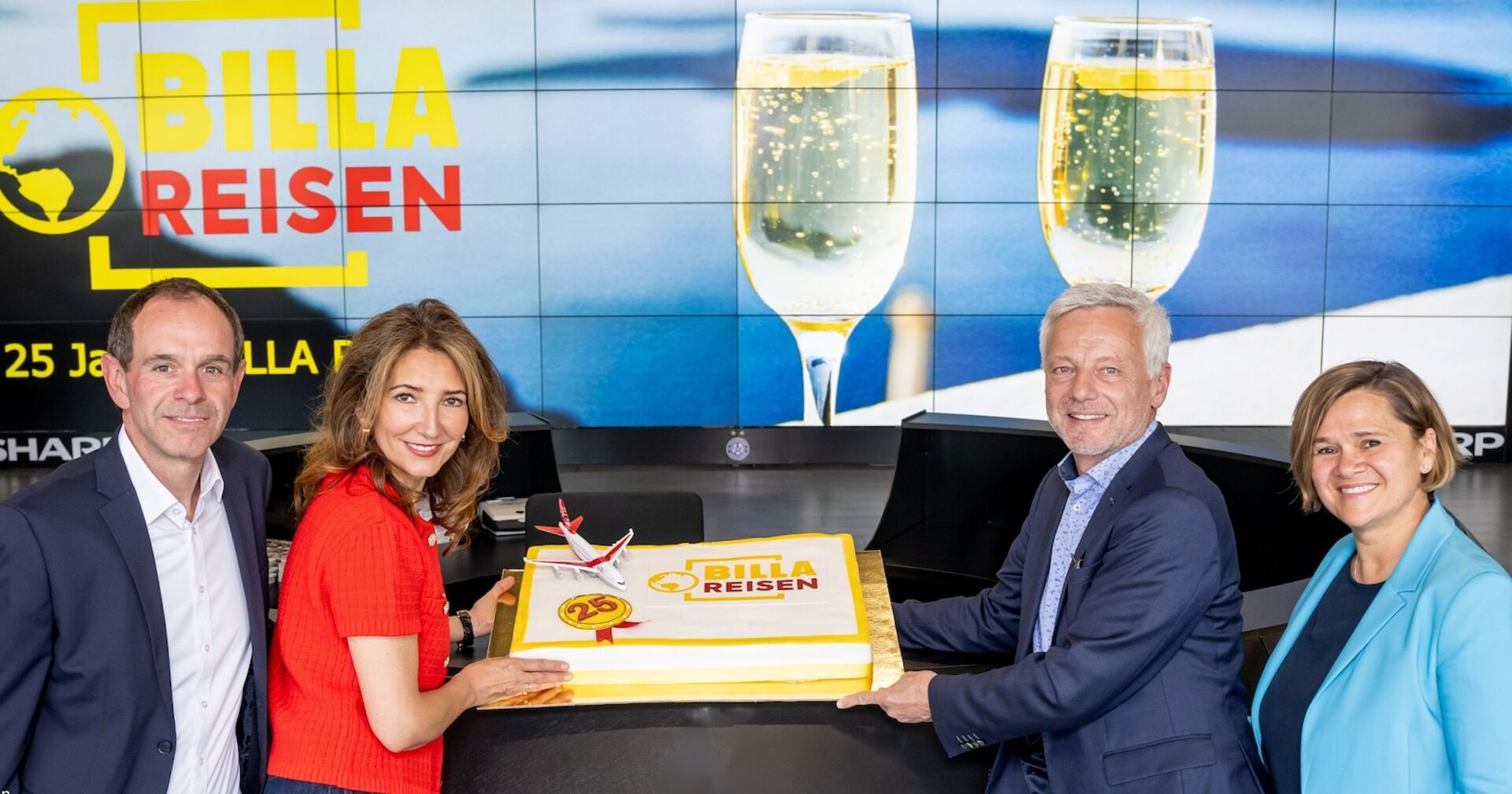 Jeweils zwei Personen links und rechts neben einer großen Torte