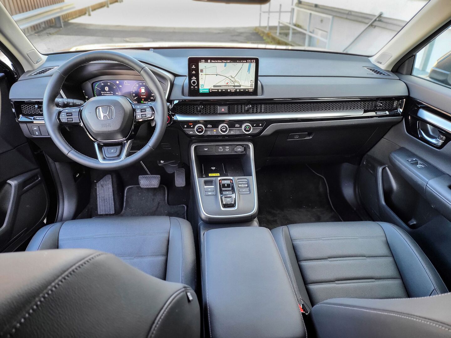Das Innere des Honda CR-V: Silbergraue Sitze, in der Mitte das Navi.  Das Lenkrad mach einen kompakten Eindruck, wie das ganz Armaturenbrett.