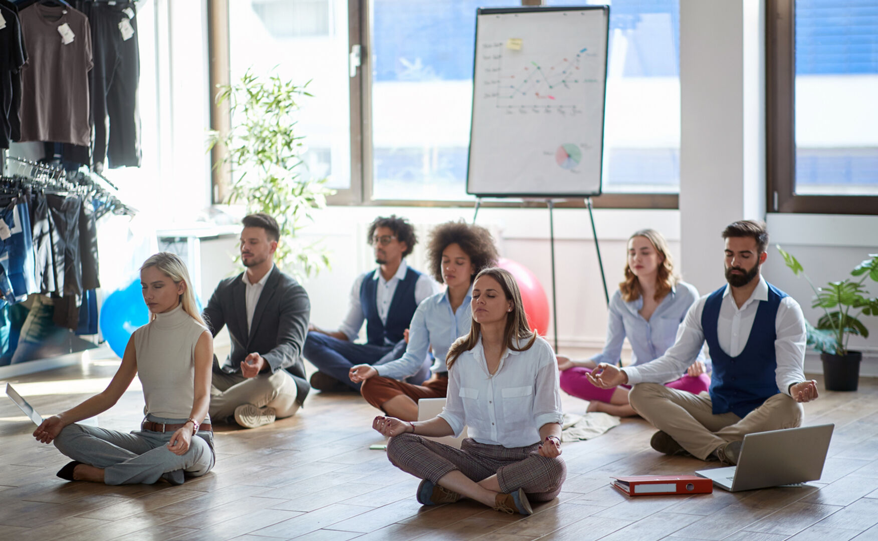 Eine Gruppe von Menschen macht Yoga in einem Büro.