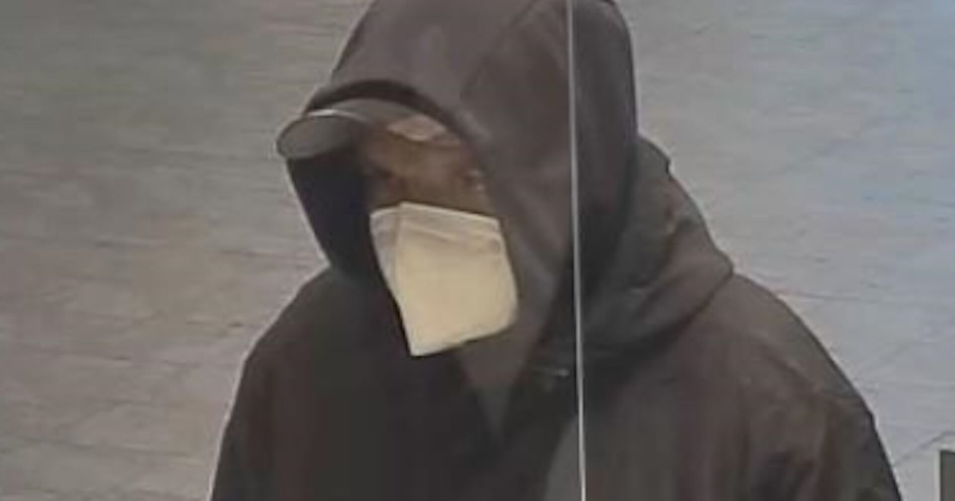 Der vermummte Bankräuber mit FFP2-Maske.