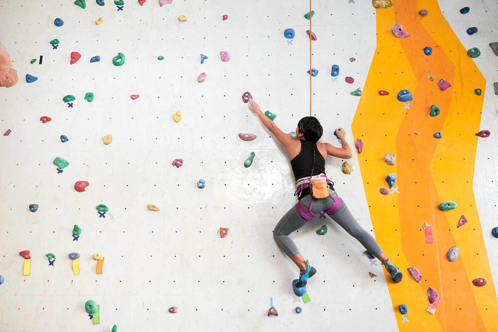 Frau an der Kletterwand | Credit: iStock.com/DragonImages