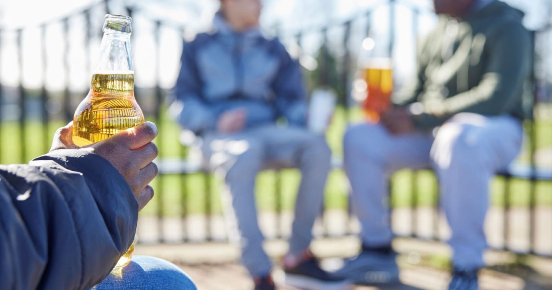 Ein Kind hat eine Flasche Alkohol in der Hand.