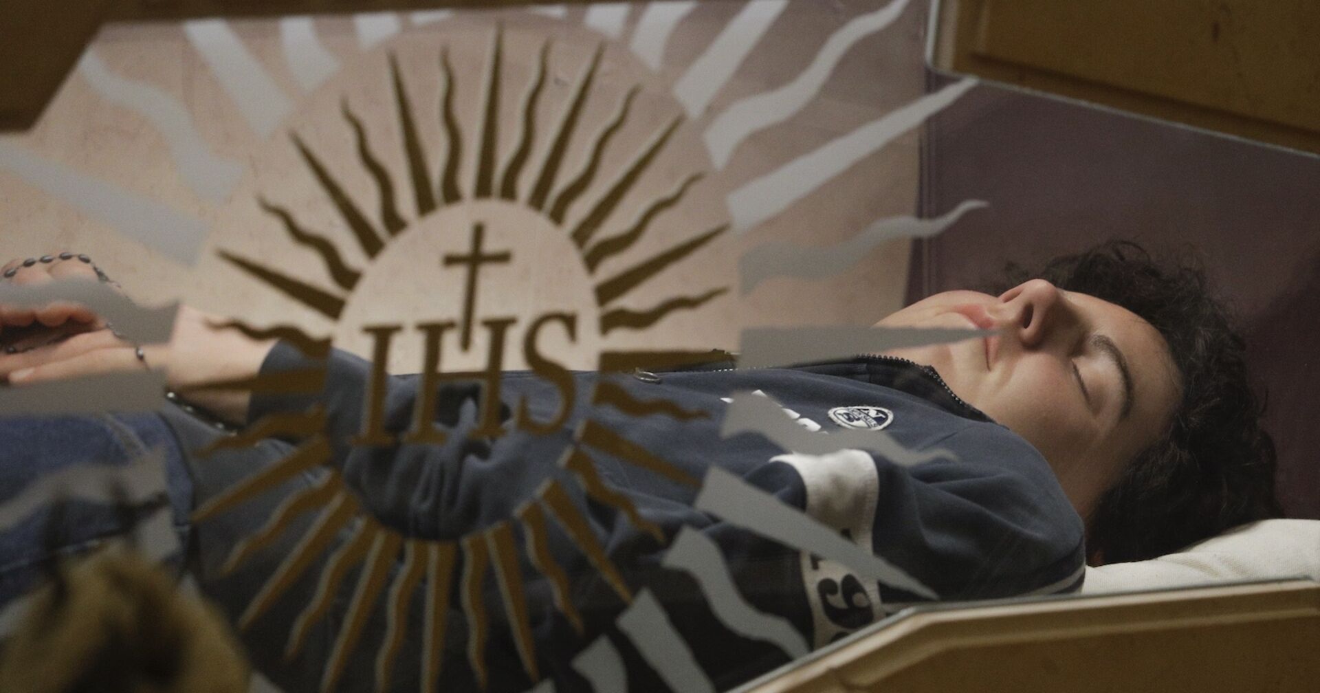 Carlo Acutis nach seinem Tod, friedvoll in einem gläsernen Sarg liegend