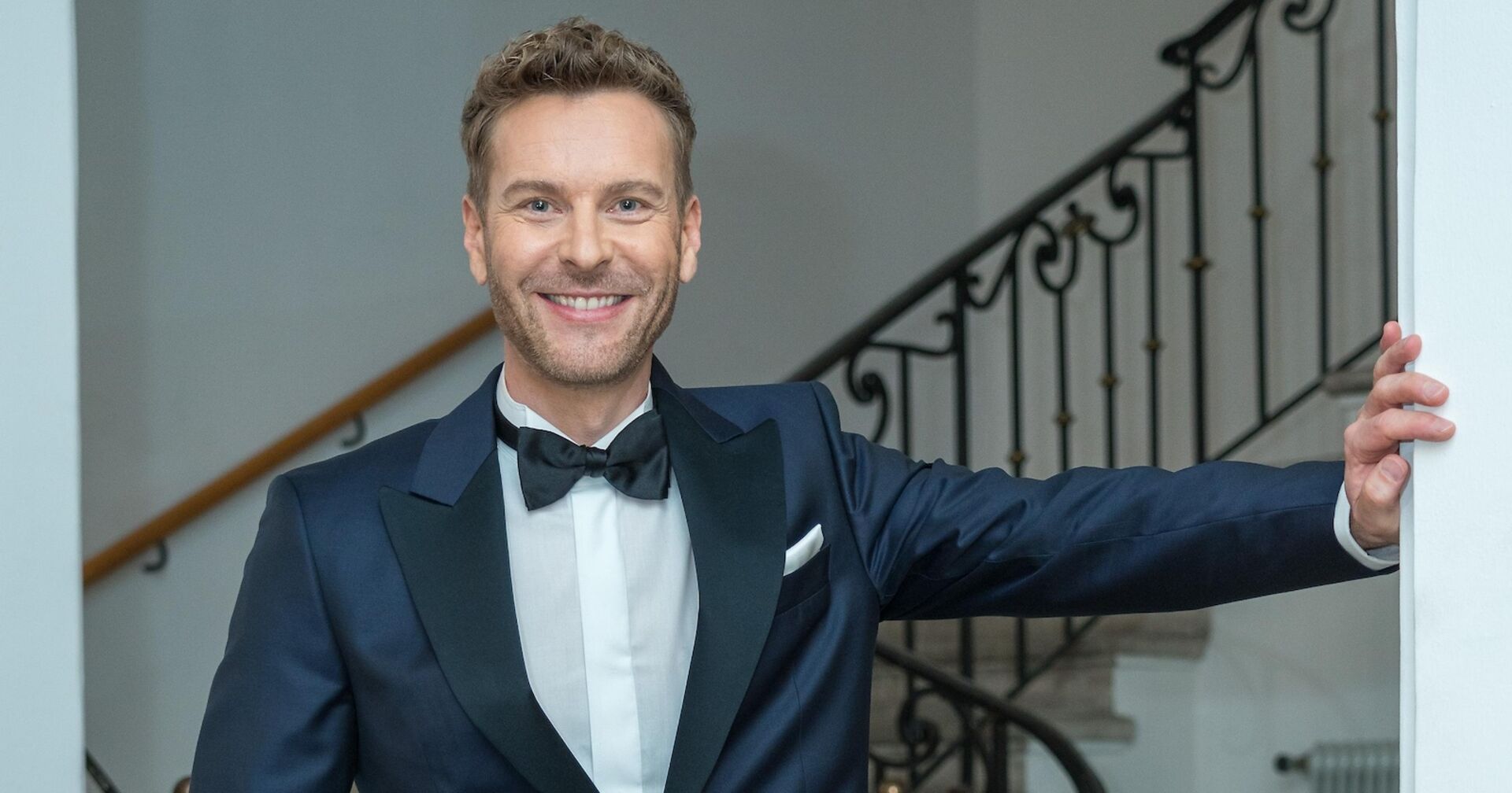 Christoph Feuerstein mit einem dunkelblauen Sakko und einer Fliege.