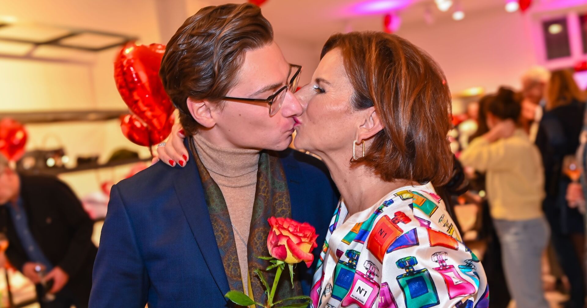 Claudia Obert küsst ihren Partner Max Suhr und hält eine Rose in der Hand.