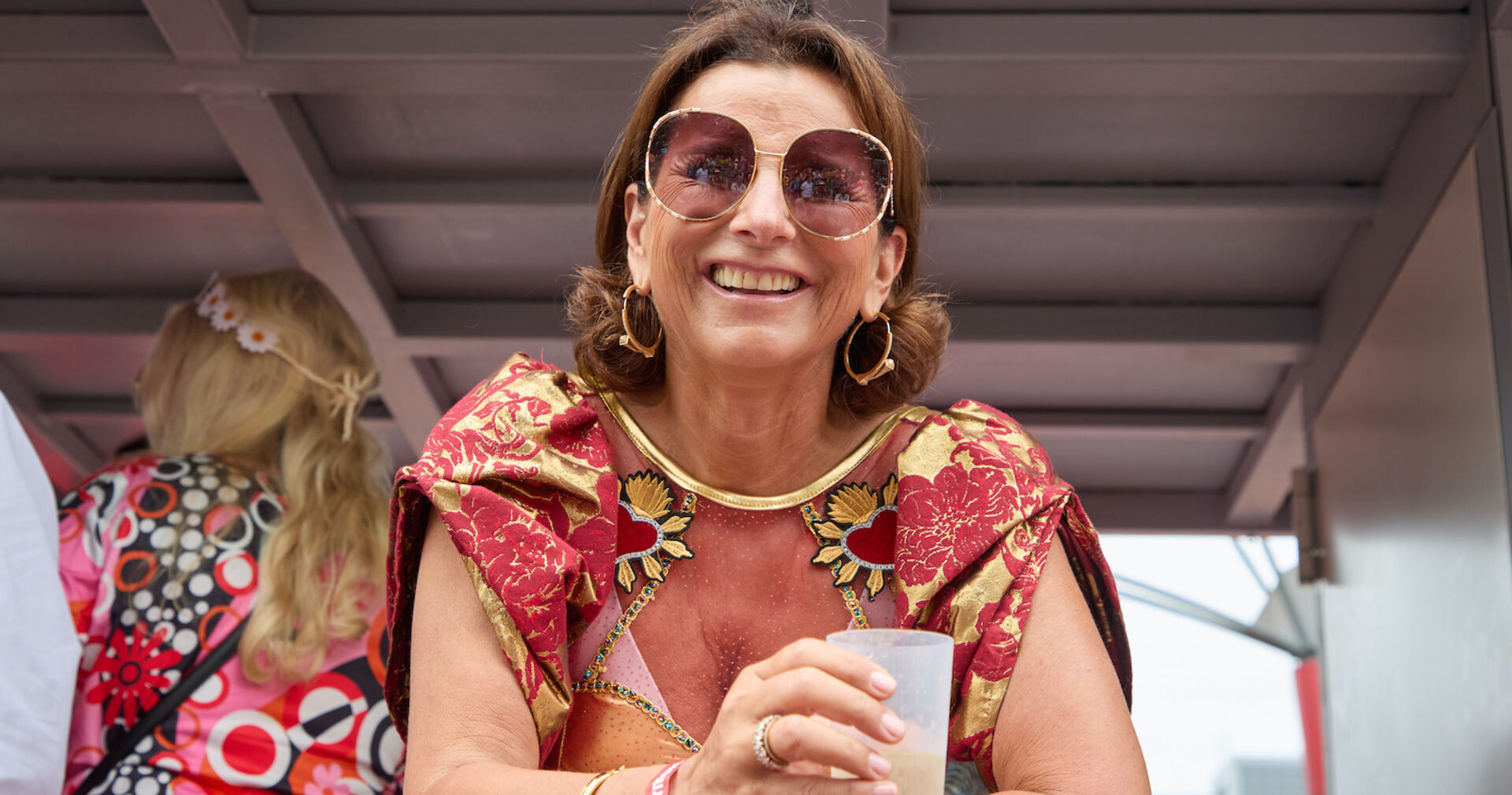 Claudia Obert mit einem Drink und einer Sonnenbrille.