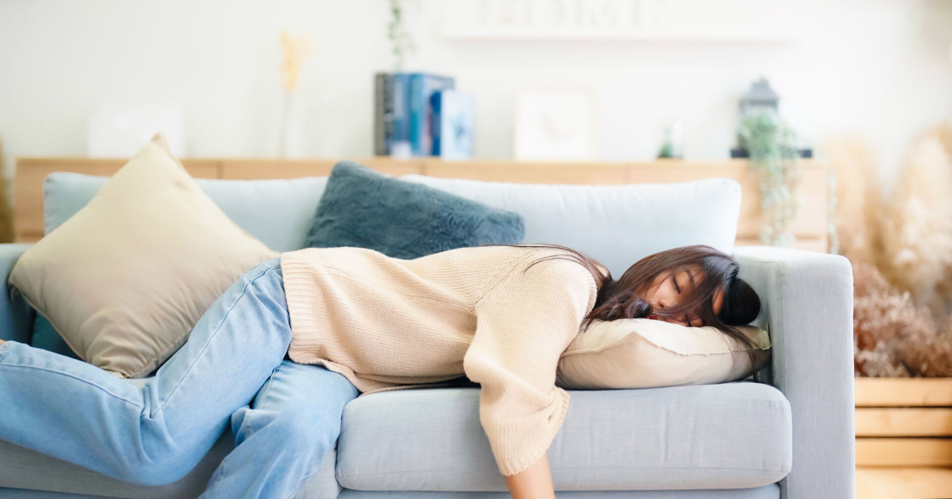 Frau liegt erschöpft auf einem Sofa | Credit: iStock.com/marchmeena29