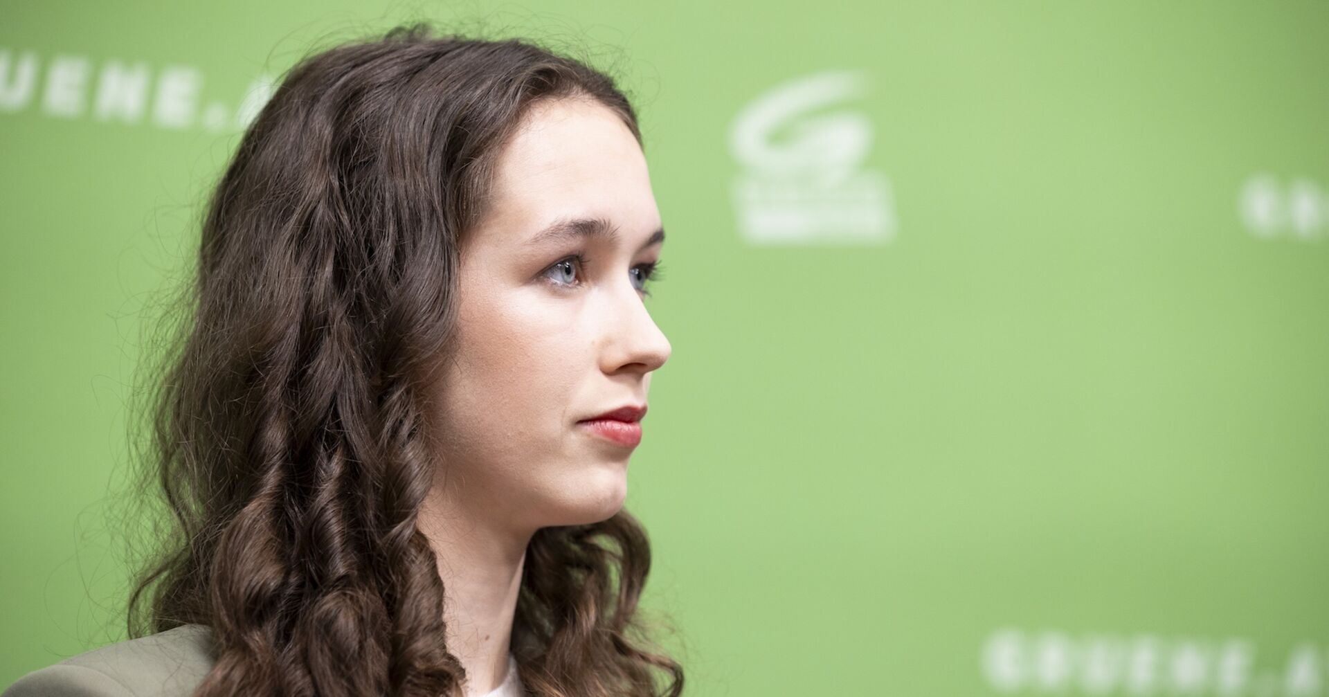 EU-Spitzenkandidatin Lena Schilling vor der Pressewand der Grünen.