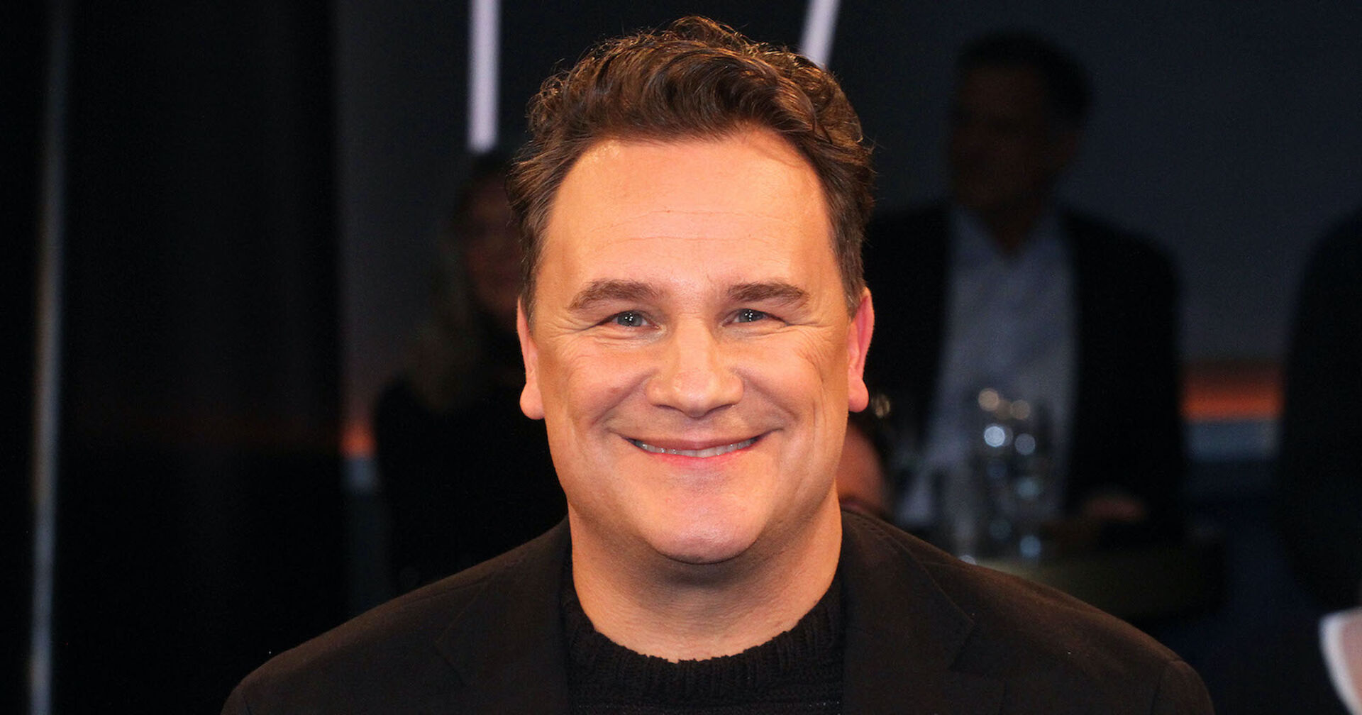 Guido Maria Kretschmer mit einem schwarzen Blazer und einem schwarzen T-Shirt.