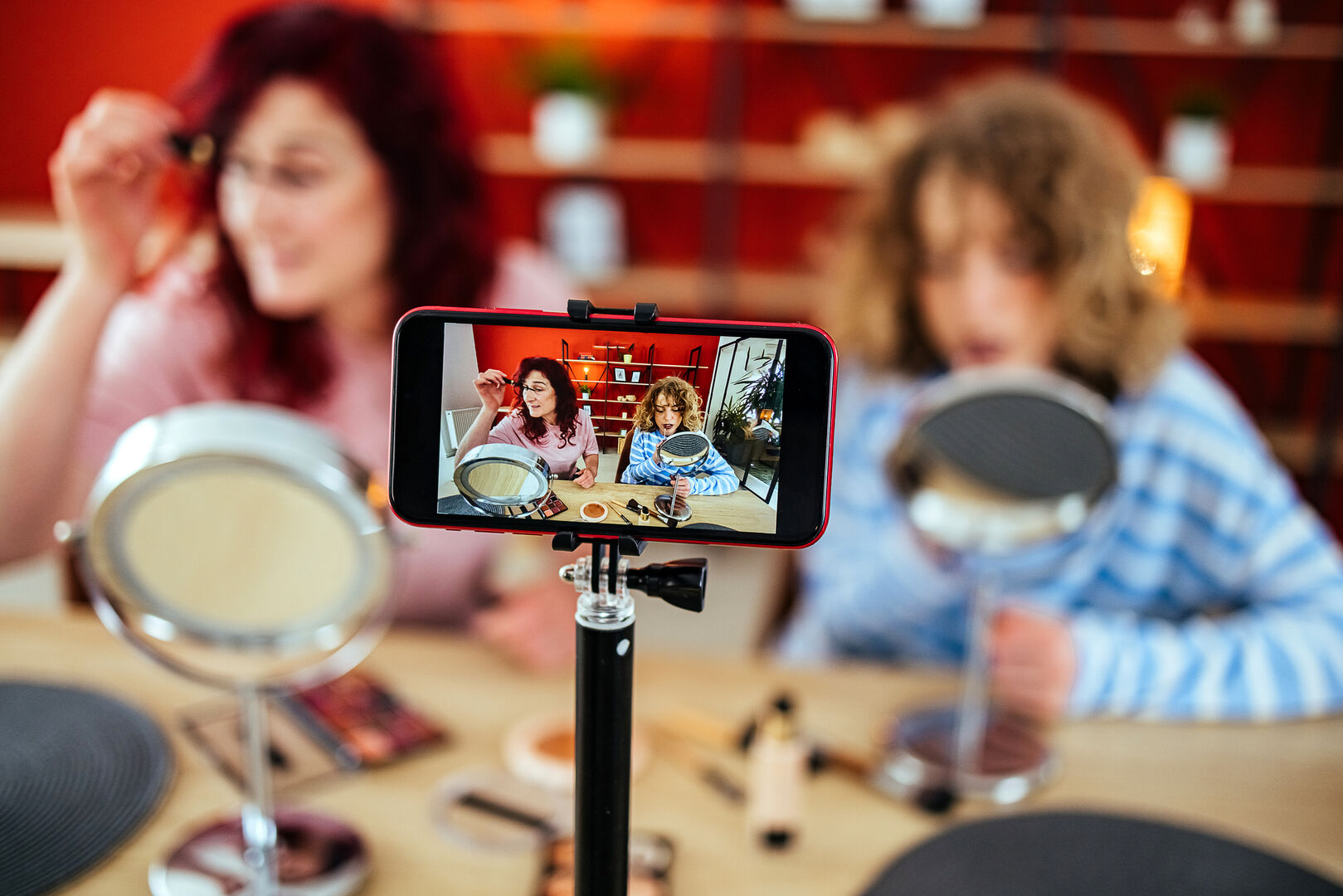 Eine Mutter und ihr Kind schminken sich gemeinsam und filmen sich dabei.