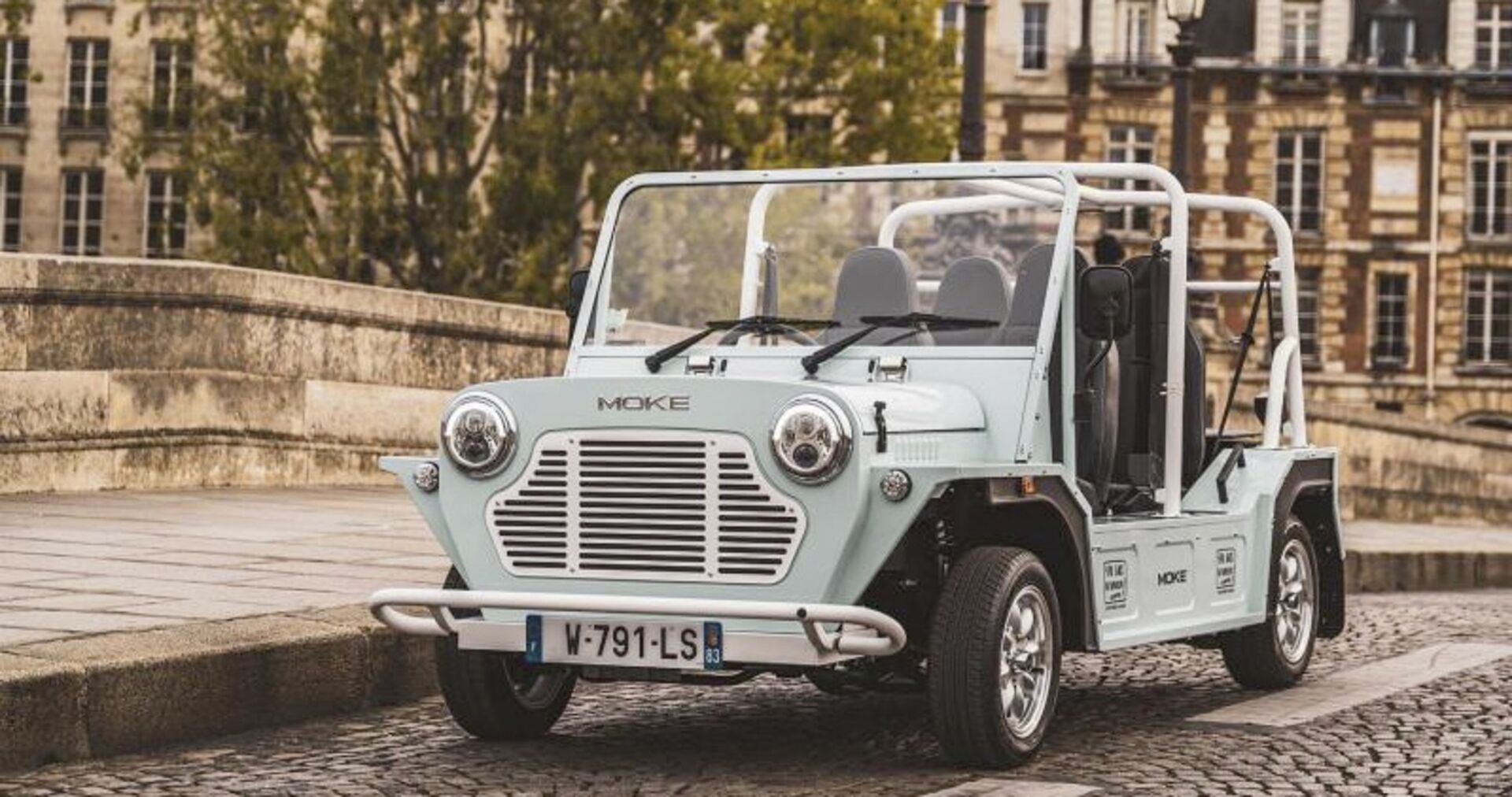 Ein kleines Cabrio auf einer Brücke mit Kopfsteinpflaster