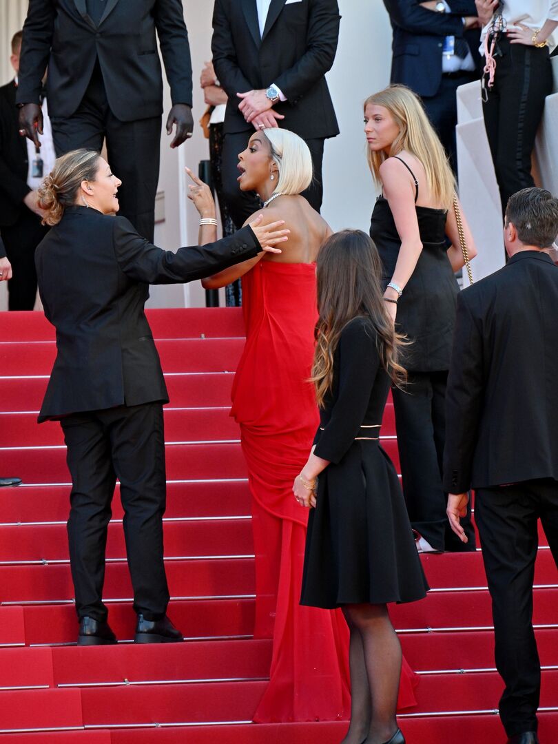 Kelly Rowland auf der Treppe in Cannes. Sie diskutiert mit einem Mitarbeiter.