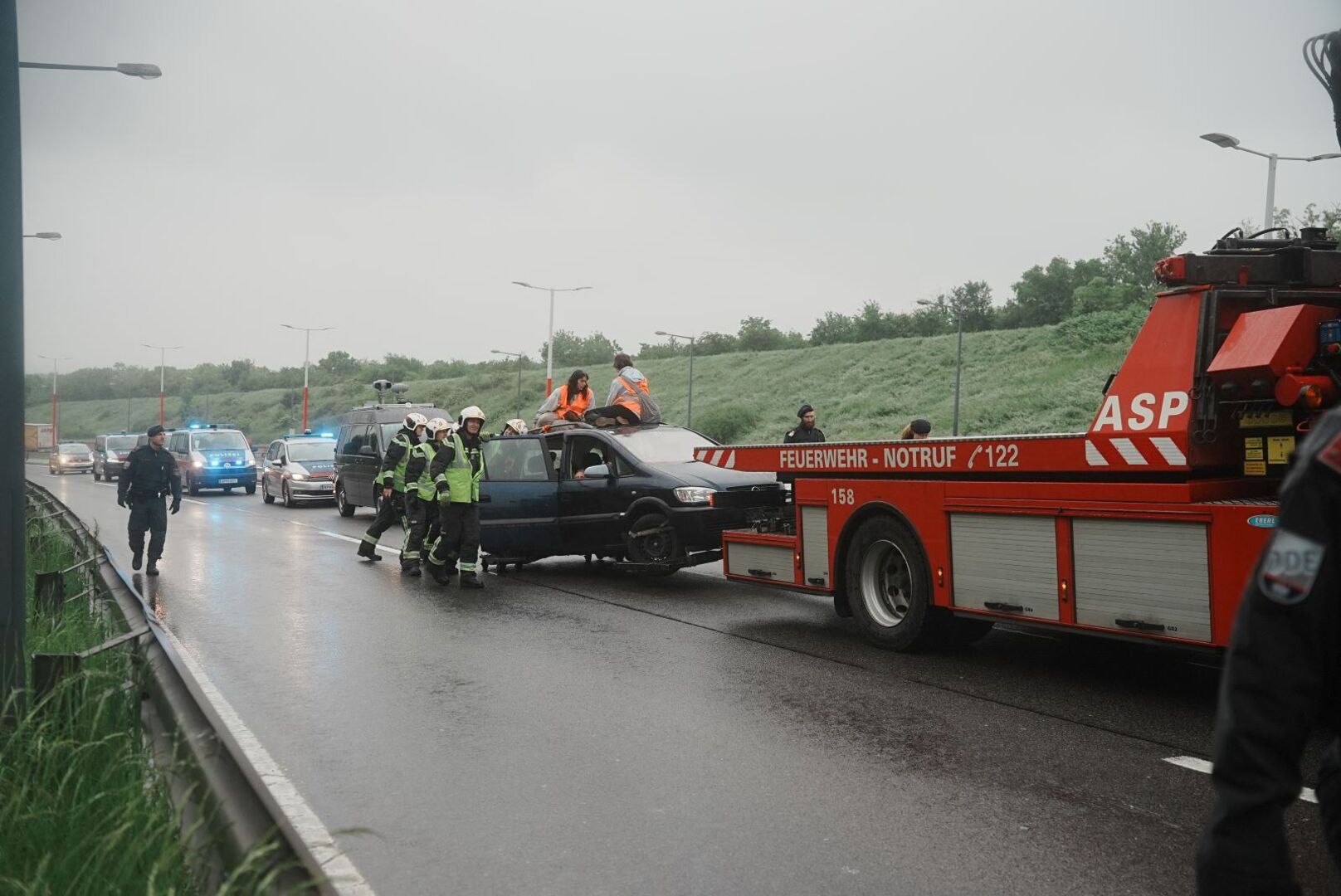 Feuerwehr schleppt Klimaaktivisten ab.