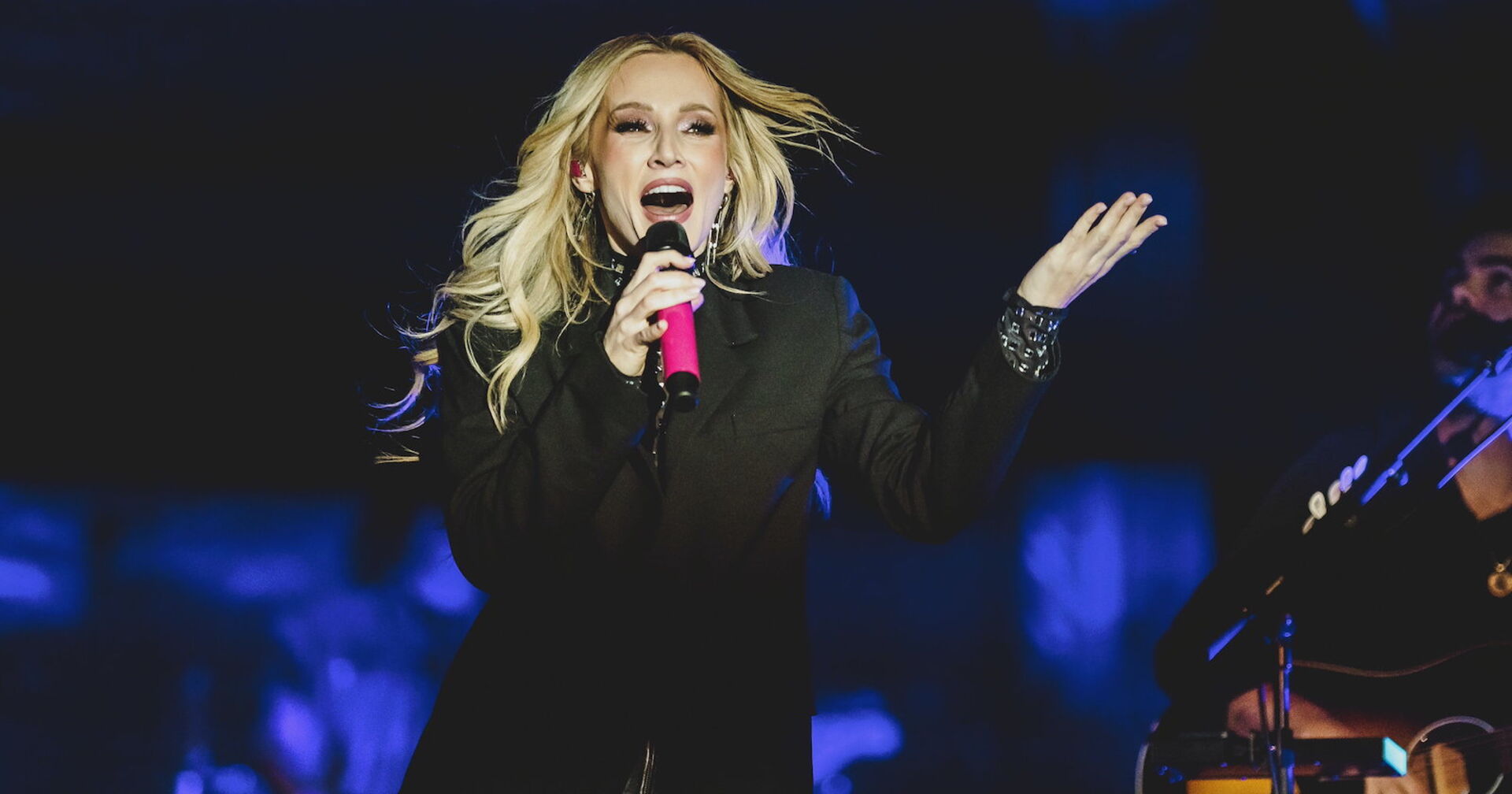 Melissa Naschenweng mit offenen blonden Haaren auf der Bühne.