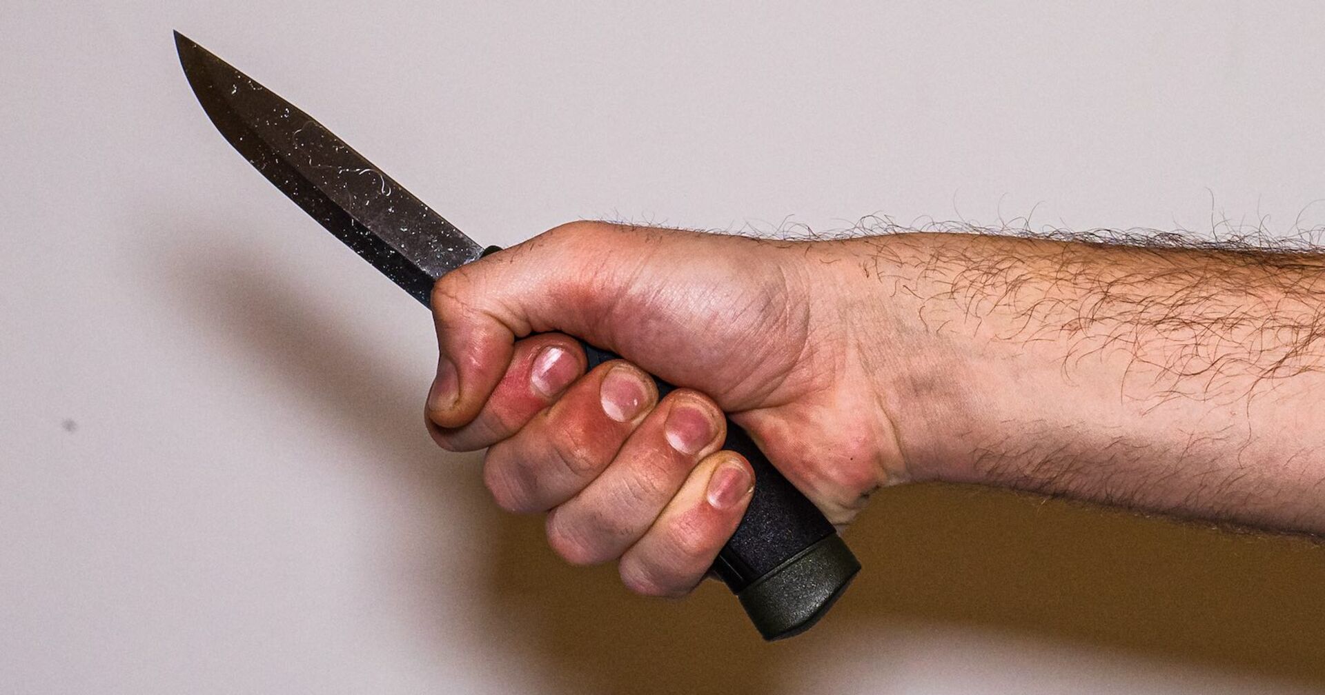 Die Hand eines Mannes, der ein Messer hält.