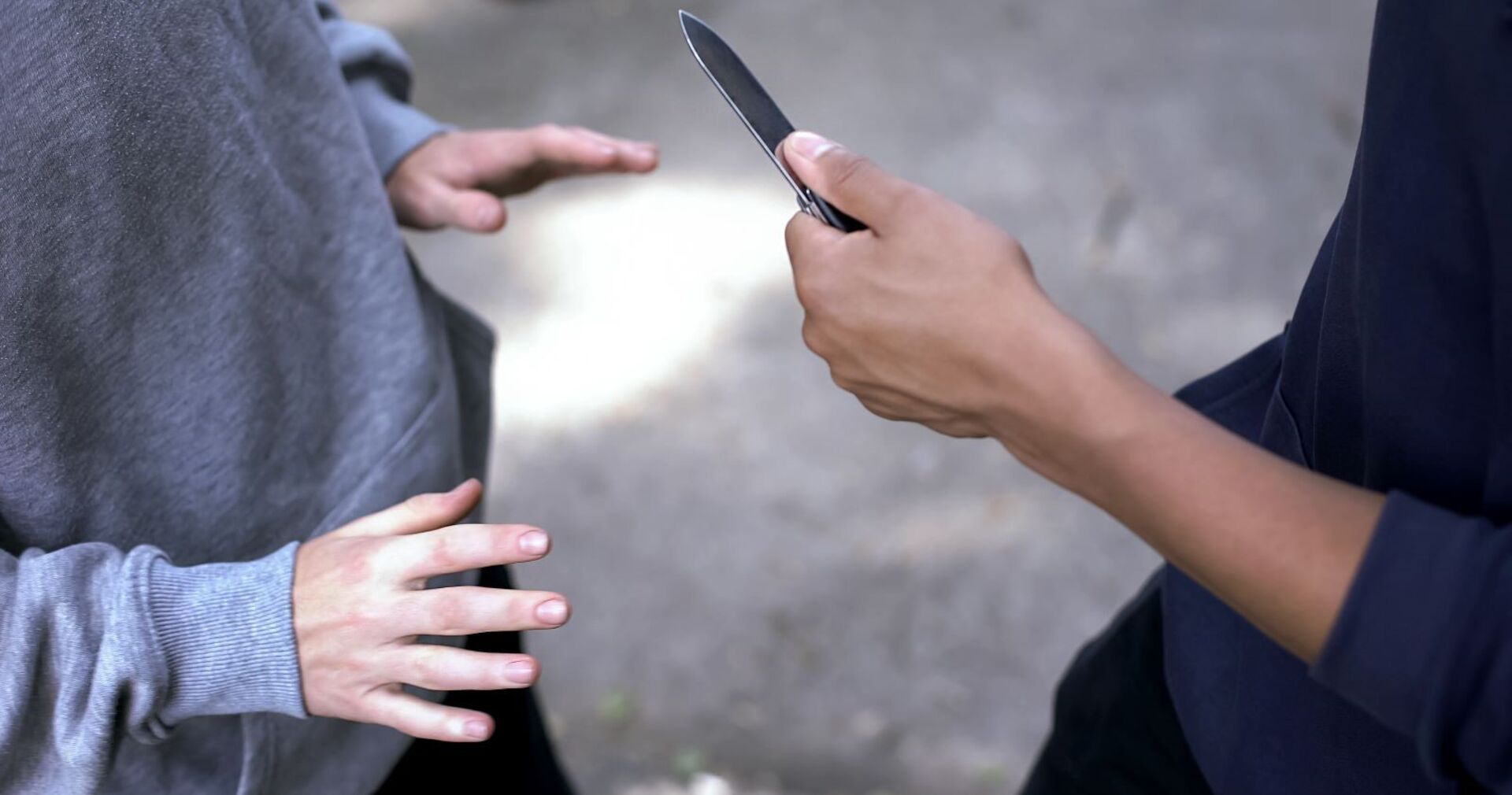 Ein Mann bedroht einen anderen mit einem Messer.