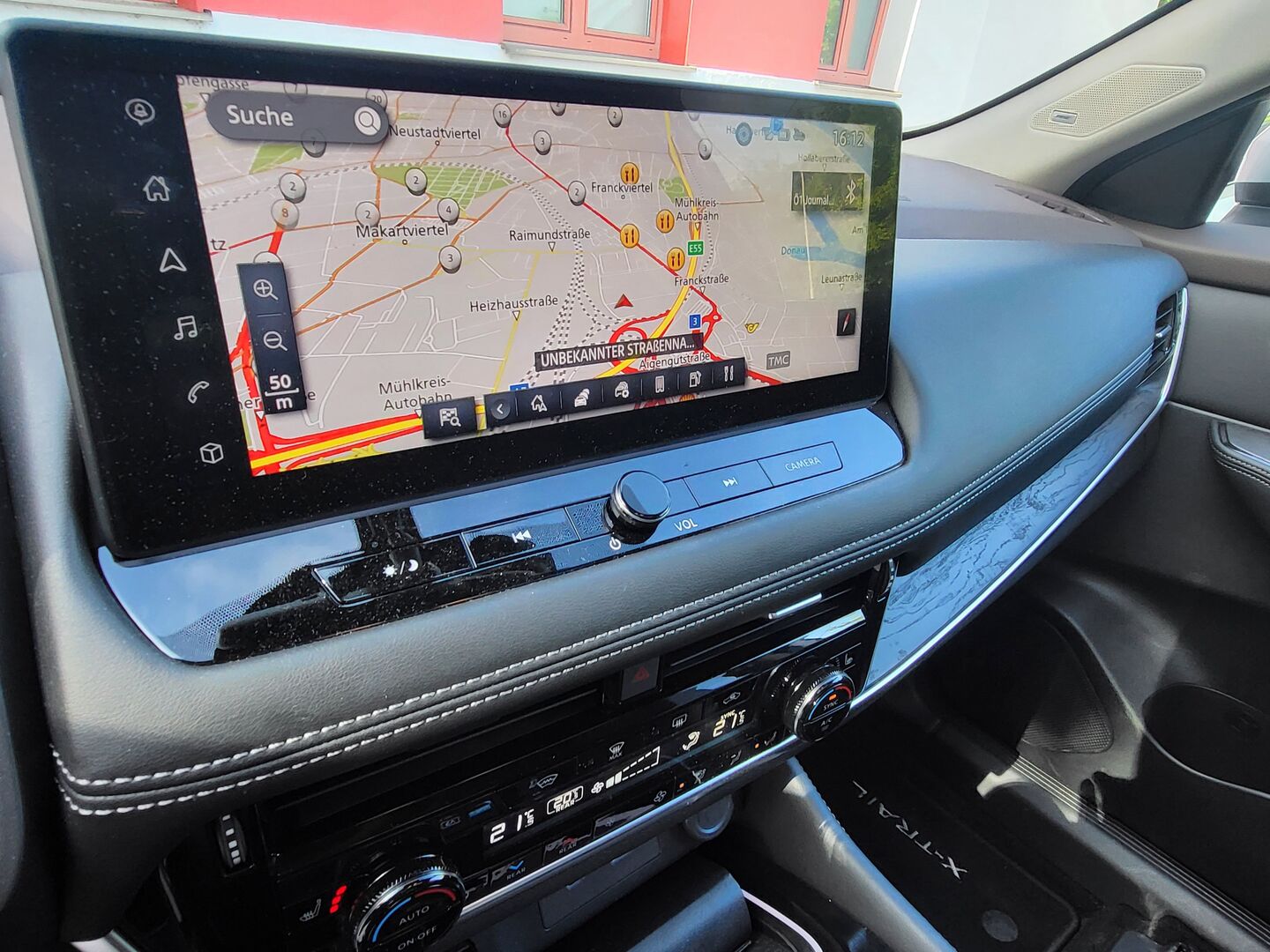 Das Display des Nissan X-Trail zeigt eine Landkarte des Stadtgebietes von Linz. Darunter sind verschiedenen Knöpfe und Schalter zu sehe. Damit kann unter anderem die Klimaanlage und das Radio bedient werden.