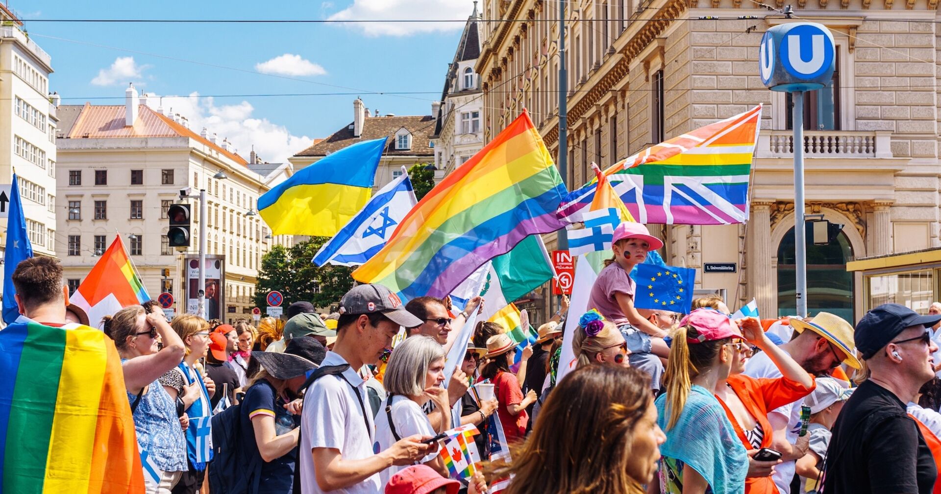 Menschen mit Flaggen bei der Vienna Pride 2022 in Wien