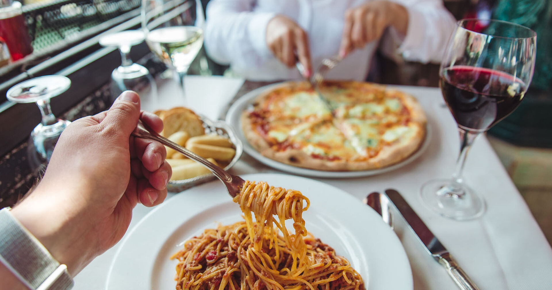 Paar isst Pizza und Pasta | Credit: iStock.com/Vera_Petrunina