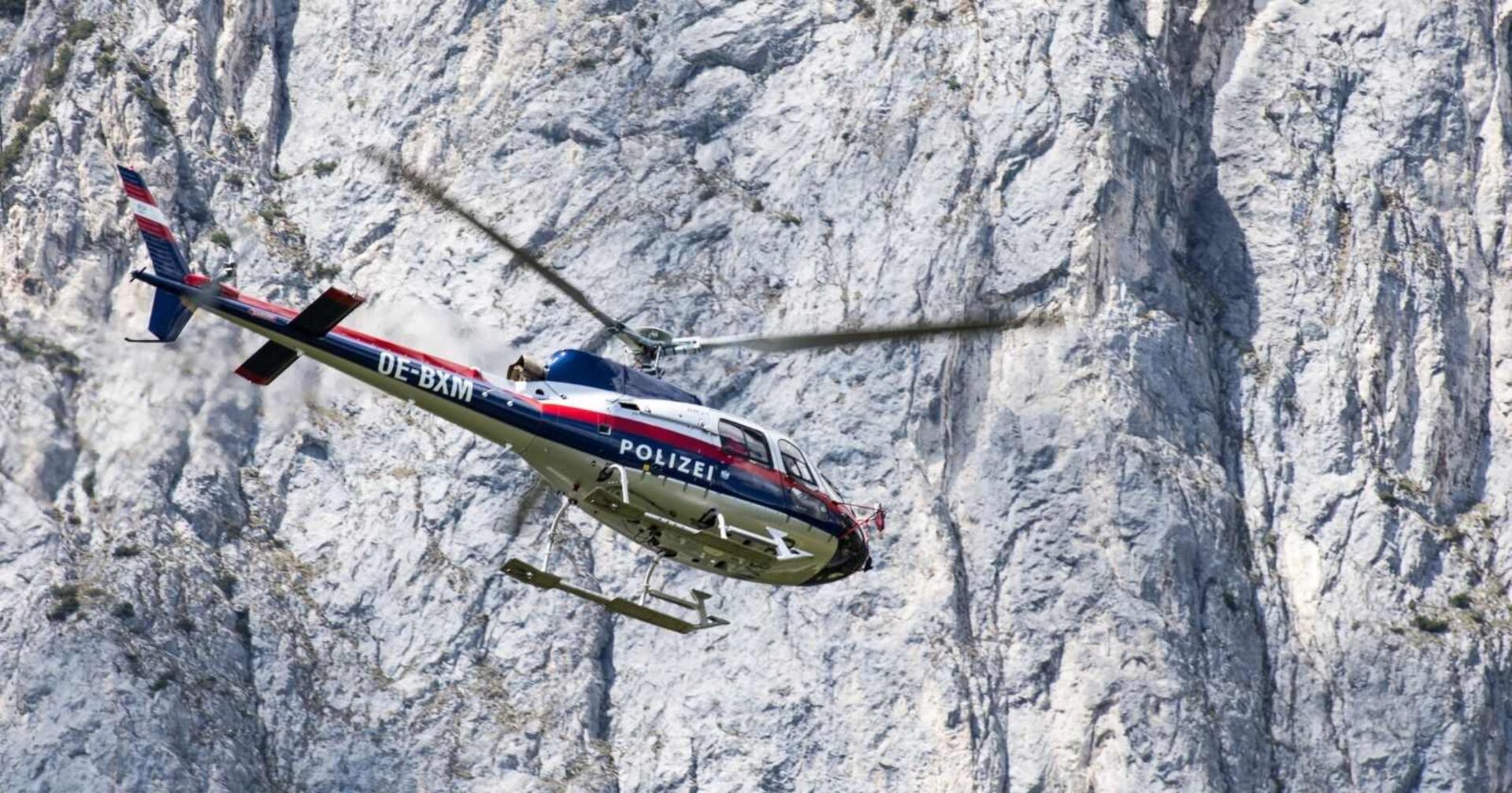 &quot;Libelle&quot;-Polizeihubschrauber in felsigem Gelände.