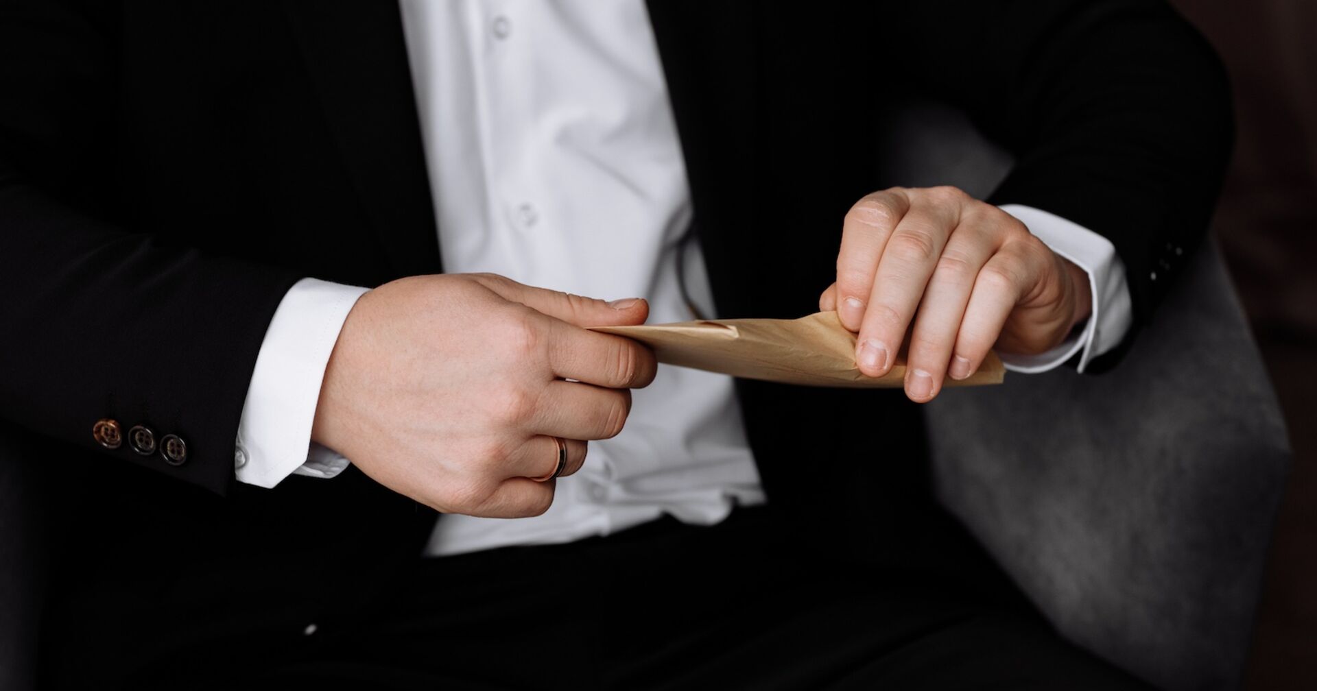 Ein Priester öffnet ein Kuvert.